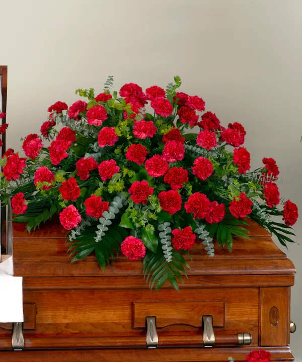    Always Remember   Carnation Casket Spray  - A spray of vibrant carnations mixed with greenery designed as a touching tribute for the casket. A meaningful expression of sympathy, this carnation casket spray is a beautiful way to pay respects and celebrate a loved one’s memory.Color Option Available  .Pink.White,Red   If you do not see a color option you are interested in, please give us a call