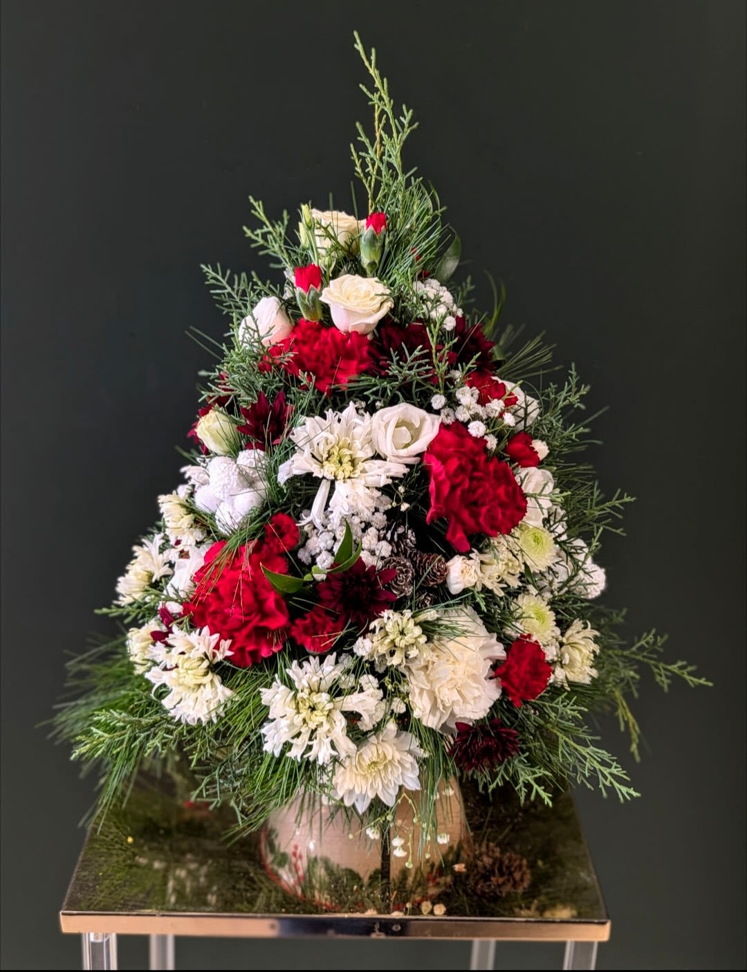 16 inch Christmas tree arrangement  - This is one cool arrangement for those who want to get extra fancy, or for those who want just a touch of whimsy. This arrangement looks like a miniature Christmas tree and will last through the holidays and will smell fantastic and fresh! This is by far our most popular item for the holidays. Each tree will look slightly different and will offer a great holiday show!