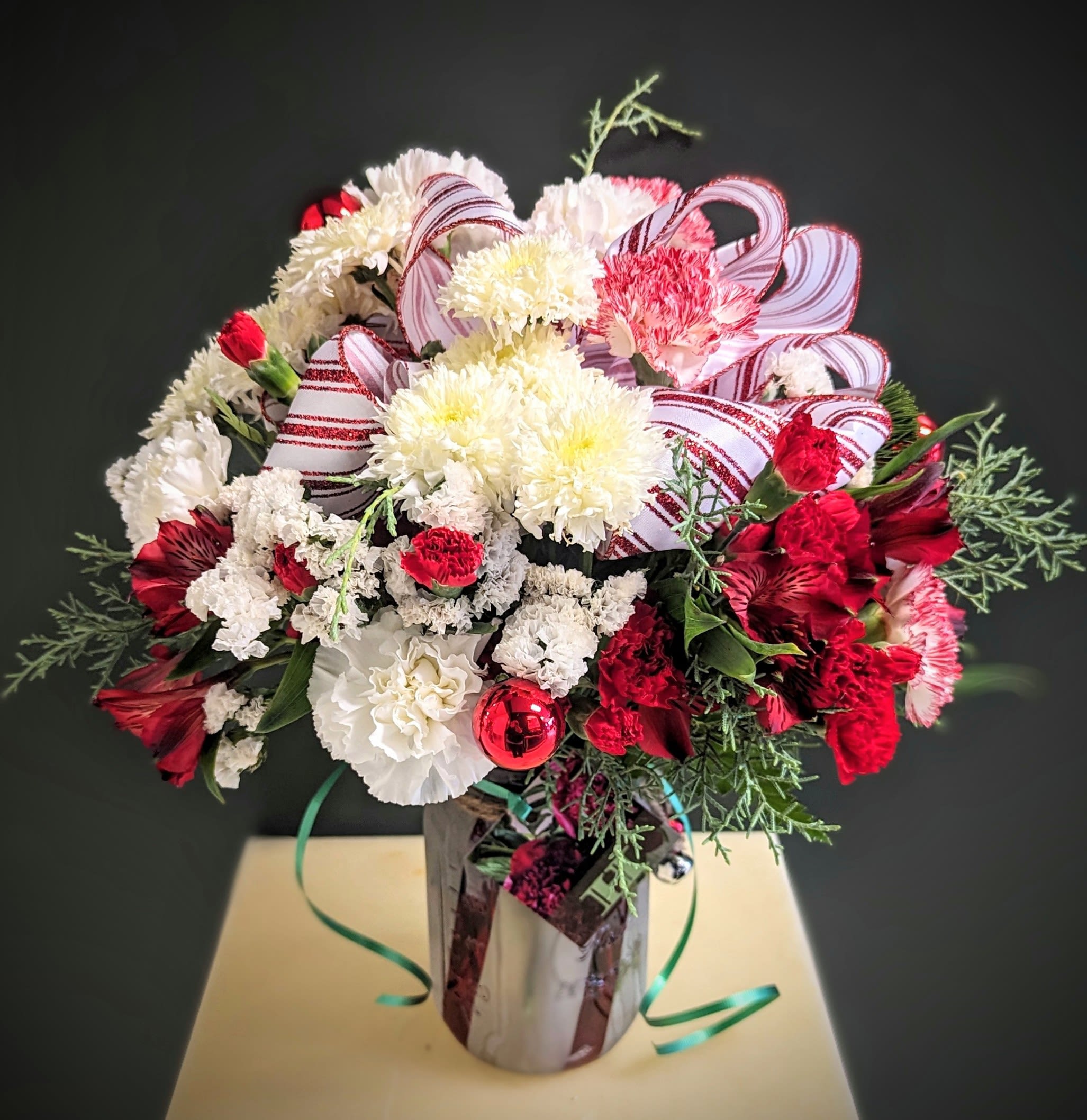 Holiday Vase Red and White  - Send some holiday cheer this year with a red and white floral arrangement complete with holiday trim and several long lasting floral choices to make the holiday stretch! 