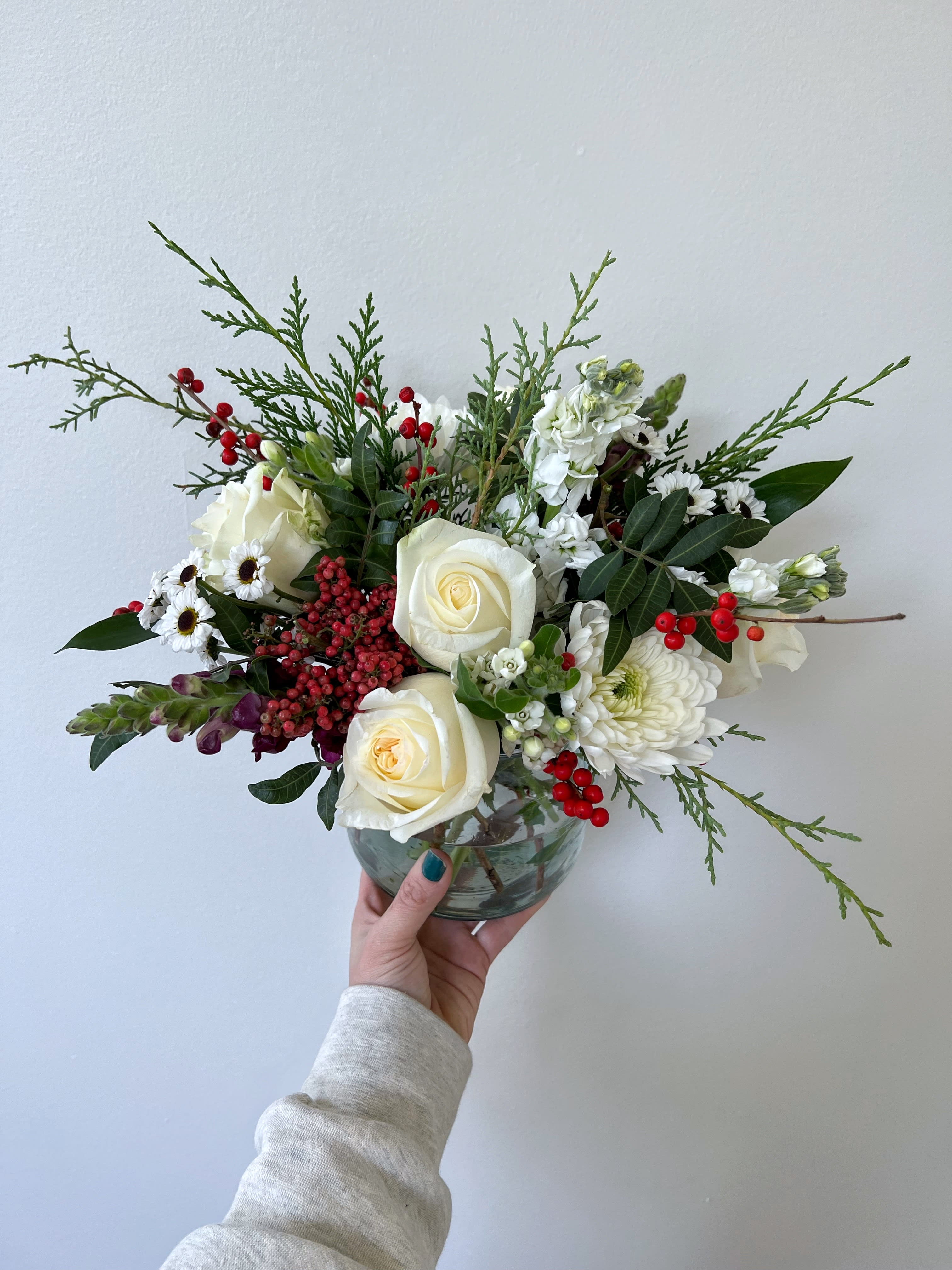 Very Merry - A lush mix of season red and white florals, adorned with fresh berries and greenery.  Premium product is shown.