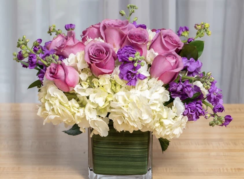 Lavender Spring - A Spring mix of lavender tulips, purple hyacinth, and hydrangea in a leaf wrapped vase. 