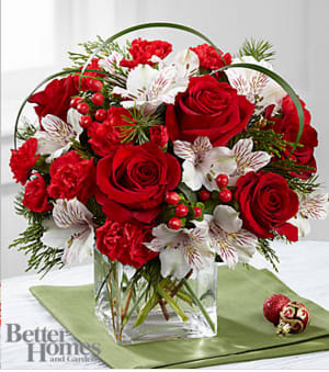 The FTD® Holiday Hopes™ Bouquet by Better Homes and Gardens® - FTD® proudly presents the Better Homes and Gardens® Holiday Hopes™ Bouquet. Spread the joy of the holiday season across the country with this simply gorgeous Christmas inspired bouquet. Rich red roses and mini carnations are beautifully accented with white Peruvian lilies, red hypericum berries, lily grass blades, and an assortment of lush holiday greens to create an exceptional fresh flower arrangement. Presented in a clear glass cube, this holiday flower bouquet sends your warmest season's greetings to any of the loves in your life. BETTER bouquet is approximately 11&quot;H x 12&quot;W. Your purchase includes a complimentary personalized gift message.