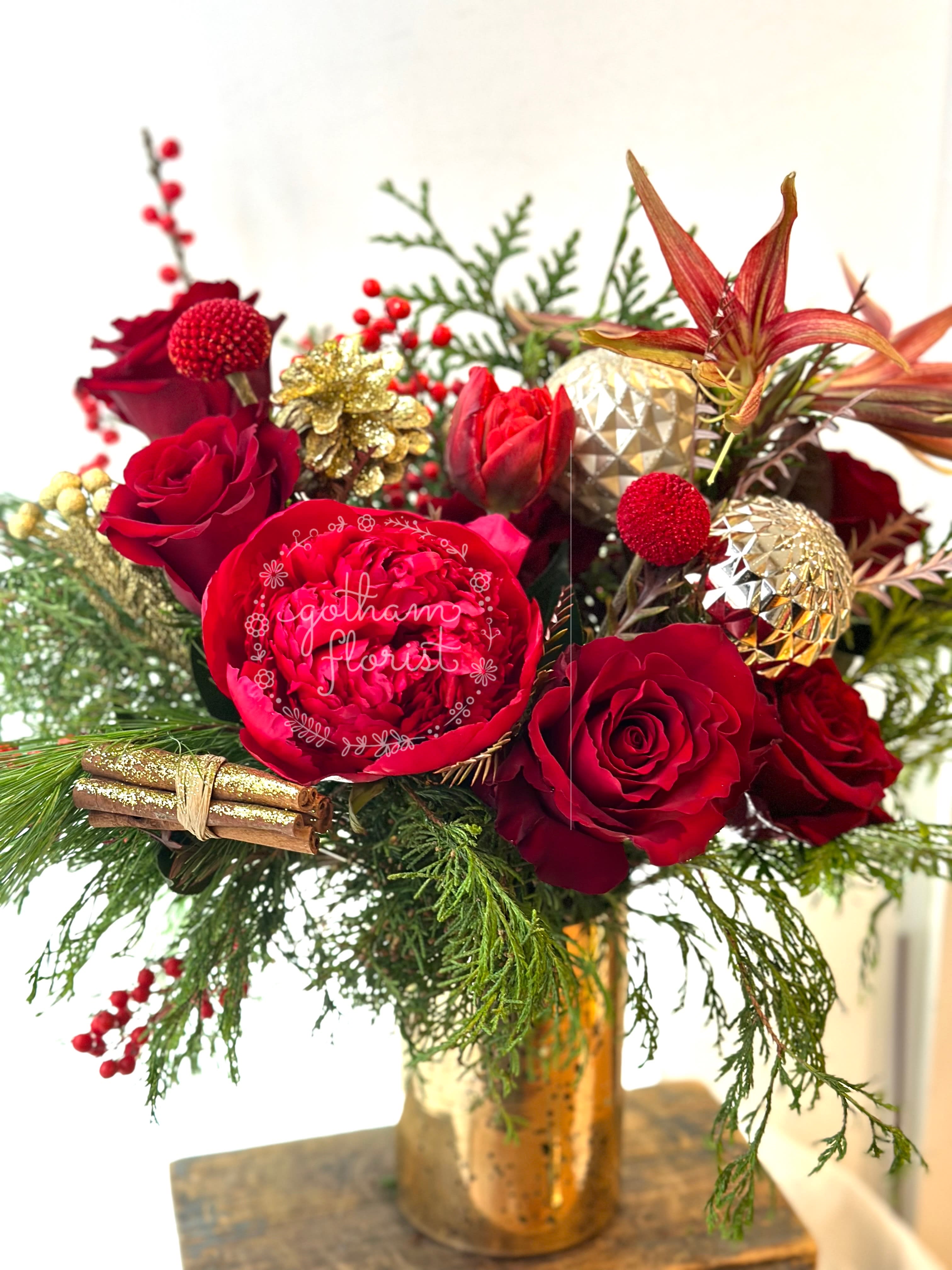 Jingle Jangle - 'Tis the season for the Jingle Jangle! This enchanting holiday flower arrangement is the perfect way to deck the halls in style. The Jingle Jangle is a dazzling celebration of the holidays. Its captivating colors and charming decorations will fill your home with a sense of wonder and joy. This stunning arrangement makes a thoughtful gift or a gorgeous addition to your own holiday decor.  • Vibrant red flowers including poinsettias, roses, and more • Adorned with sparkling ornaments, ribbons, and festive accents • Arrives in a classic red container for easy, elegant display • Long-lasting blooms that will light up your space all season  We offer same day flower delivery in Manhattan, Queens, Bronx, Brooklyn, Staten Island and West Chester counties. We have the prettiest and most luxurious flowers to choose from and our designs are unique and whimsical. We carry Peonies almost every day of the year!! Best florist, nyc, local florist, send flowers, flower delivery, same day delivery, florist around me, flower shop, best flower shop, flowers, flower delivery, peony, peonies, same day flower delivery, wedding florist, best florist nyc, nyc florist, florist near me, manhattan florist, brooklyn florist