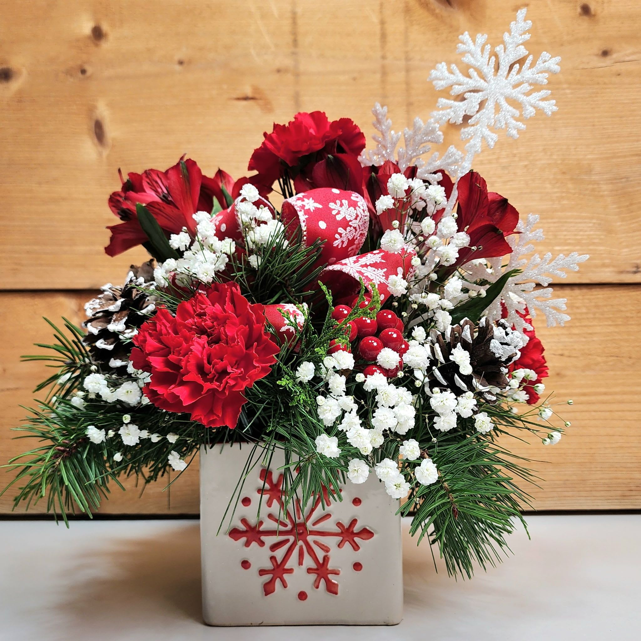 Flowers &amp; Flurries - If you get a delivery of Flowers &amp; Flurries, no cold is necessary! This arrangement comes in a white cube featuring a fun red snowflake on the front of it, and it's sure to delight! With alstroemeria, carnations, and babies breath, along with a snowflake pick and snowflake bow, this is the quintessential winter arrangement, ready to get you into the spirit of the season!  Dimensions approx. L 11&quot; x H 14&quot;