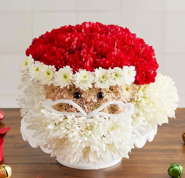 Jolly Santa - Here’s a jolly holiday favorite that really takes the cake! Our one-of-a-kind flower creation is handcrafted from red and white blooms to look just like Santa Claus, right down to his fluffy white beard and signature hat. It’s a whimsical gift for anyone who believes in the magic of Christmas, bringing a merry touch to their holiday home. 