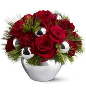 Silver Bells - Silver bells, silver bells, it's Christmas time in the city, the country or anywhere you might choose to be for the holidays. This stylish mix of red roses, carnations and silver ornaments in a silvery vase is the ultimate in urban chic.  Red roses and burgundy carnations – accented with evergreens and silver ornament balls – are delivered in a silver-toned jardiniere.  Approximately 11" (W) x 8.5" (H)  Orientation: All-Around  As Shown : TFWEB262