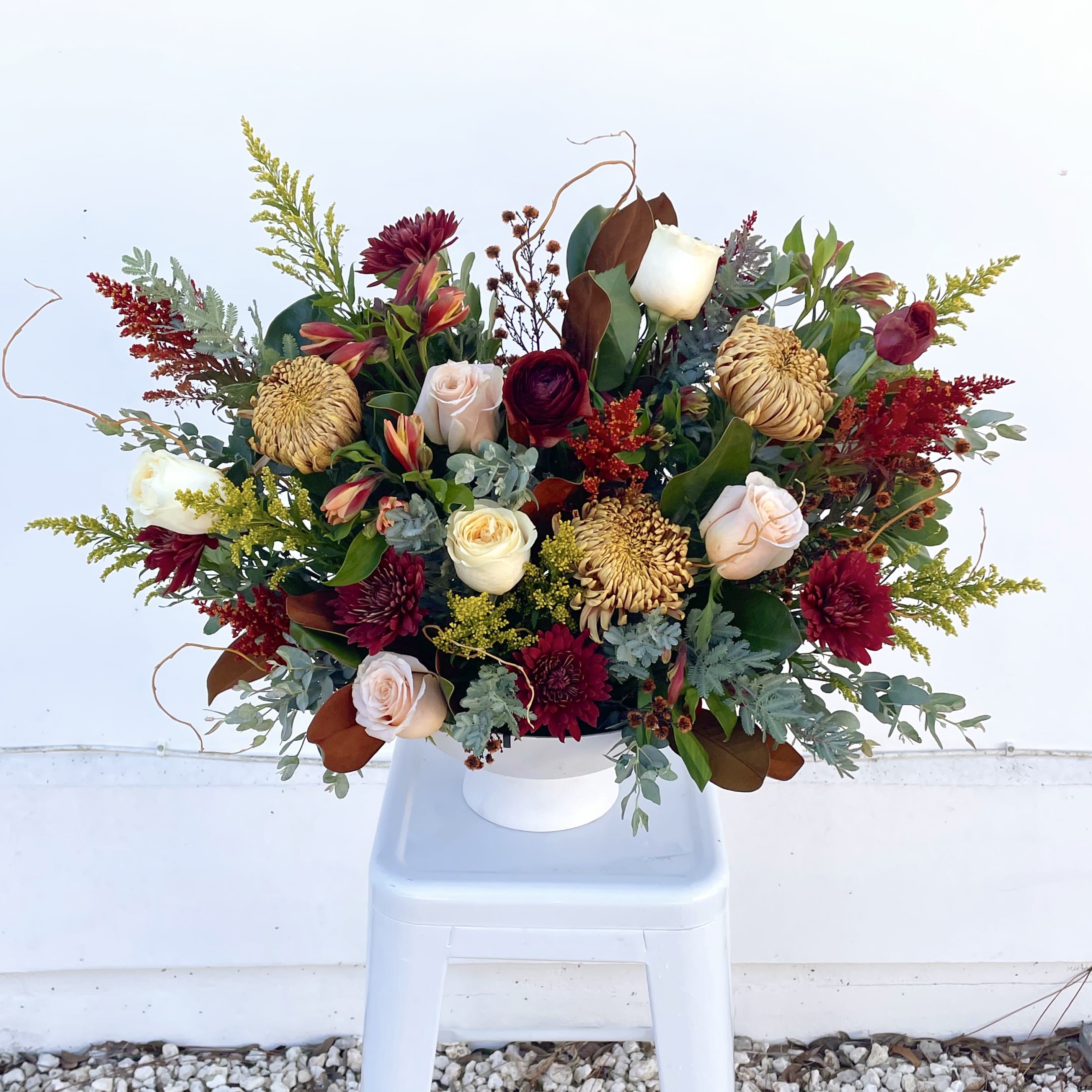 Velvet Season - Velvet Season feels like a warm autumn afternoon. Bronze mums and soft acacia glow beside light, airy willow branches, while blush and butterscotch garden roses add a gentle, dreamy touch. Burgundy ranunculus and mums bring a rich, velvety depth, like autumn’s final flourish. 