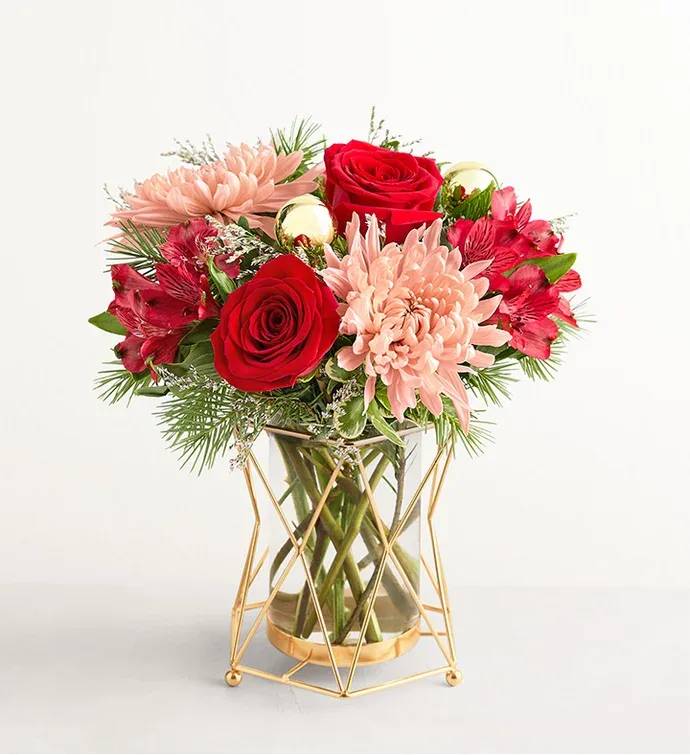 Christmas Popper™ - The very definition of merry and bright, this bouquet brings both classic beauty and contemporary grace to a holiday home. Roses, Peruvian lilies, and other blooms are accented with Christmas greenery and arranged in a gleaming metal-and-glass vase.