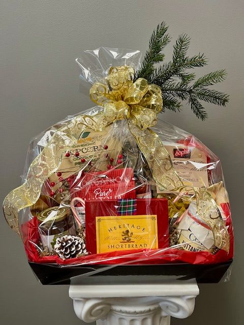 HOLIDAY GOURMET BASKET - A gourmet basket comprised of a broad array of edible items. Items may vary in each basket depending on availability. A swag of winter greens and a bow will adorn the basket.
