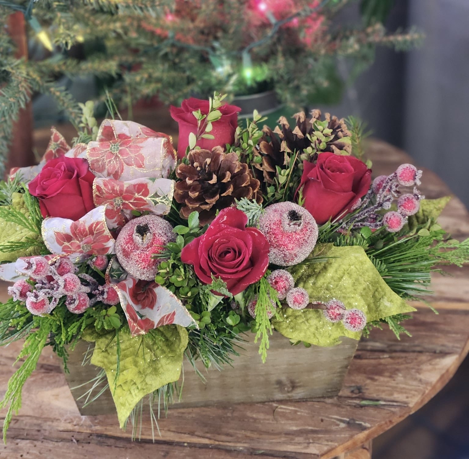 Box of Christmas - Our popular rustic wooden box filled with Christmas wonder. Fresh greens, deep red roses, sugared fruits and other decor make this arrangement a festive gift!