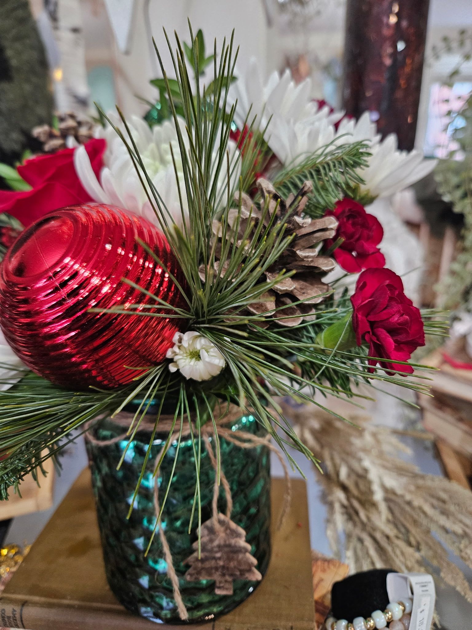 Woodland Winter Wishes - Fun winter container with red roses, mini carnations, white chrysanthemums pine and balsam with pinecones and an ornament