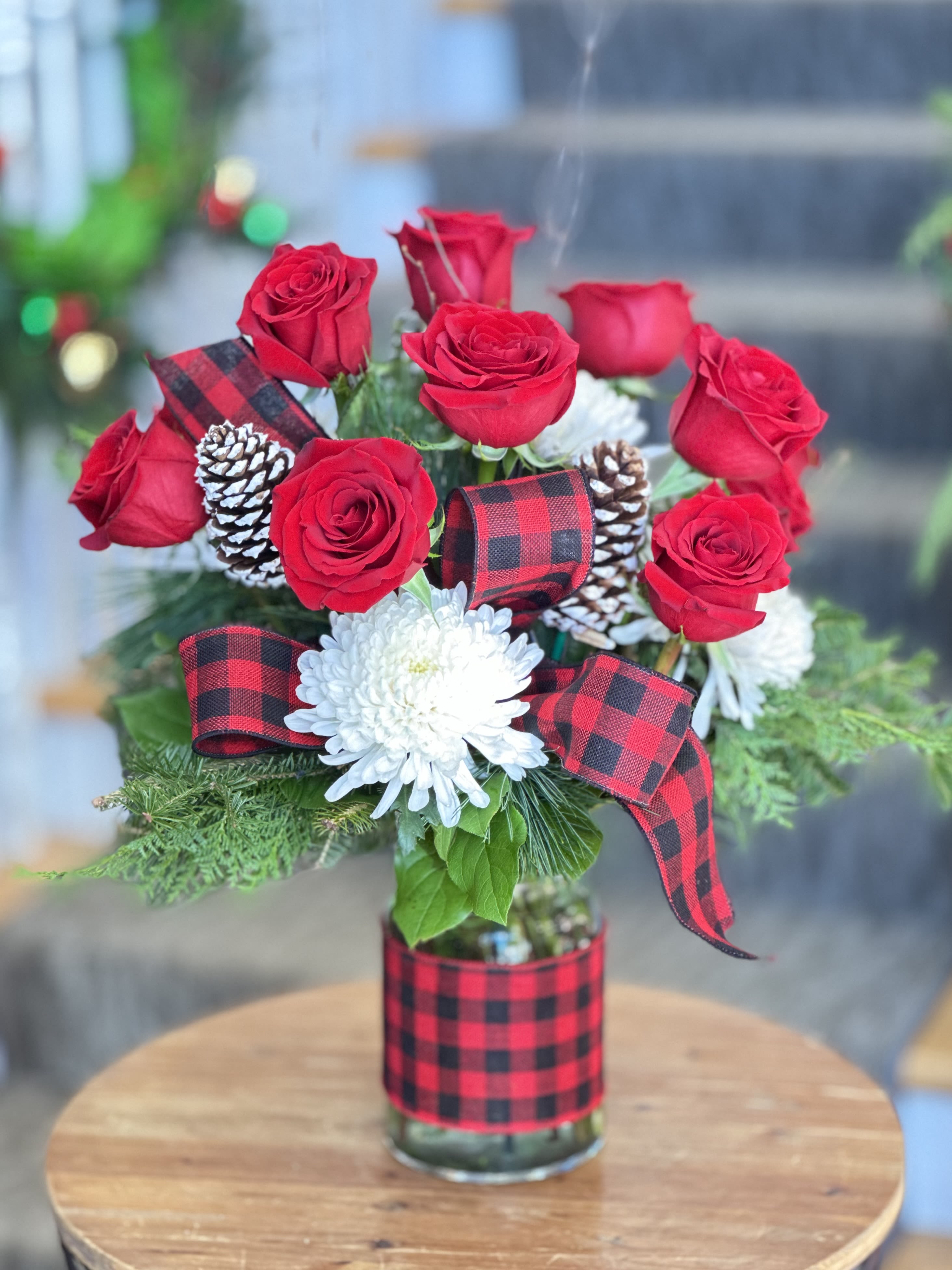 Pine &amp; Plaid Bouquet - Holiday Collection | Local Delivery Only  Celebrate the season with this cozy, festive bouquet, inspired by classic buffalo plaid. Featuring a dozen red roses, white mums, and pinecones, it's a timeless holiday arrangement desifned to bring warmth and charm to any space.