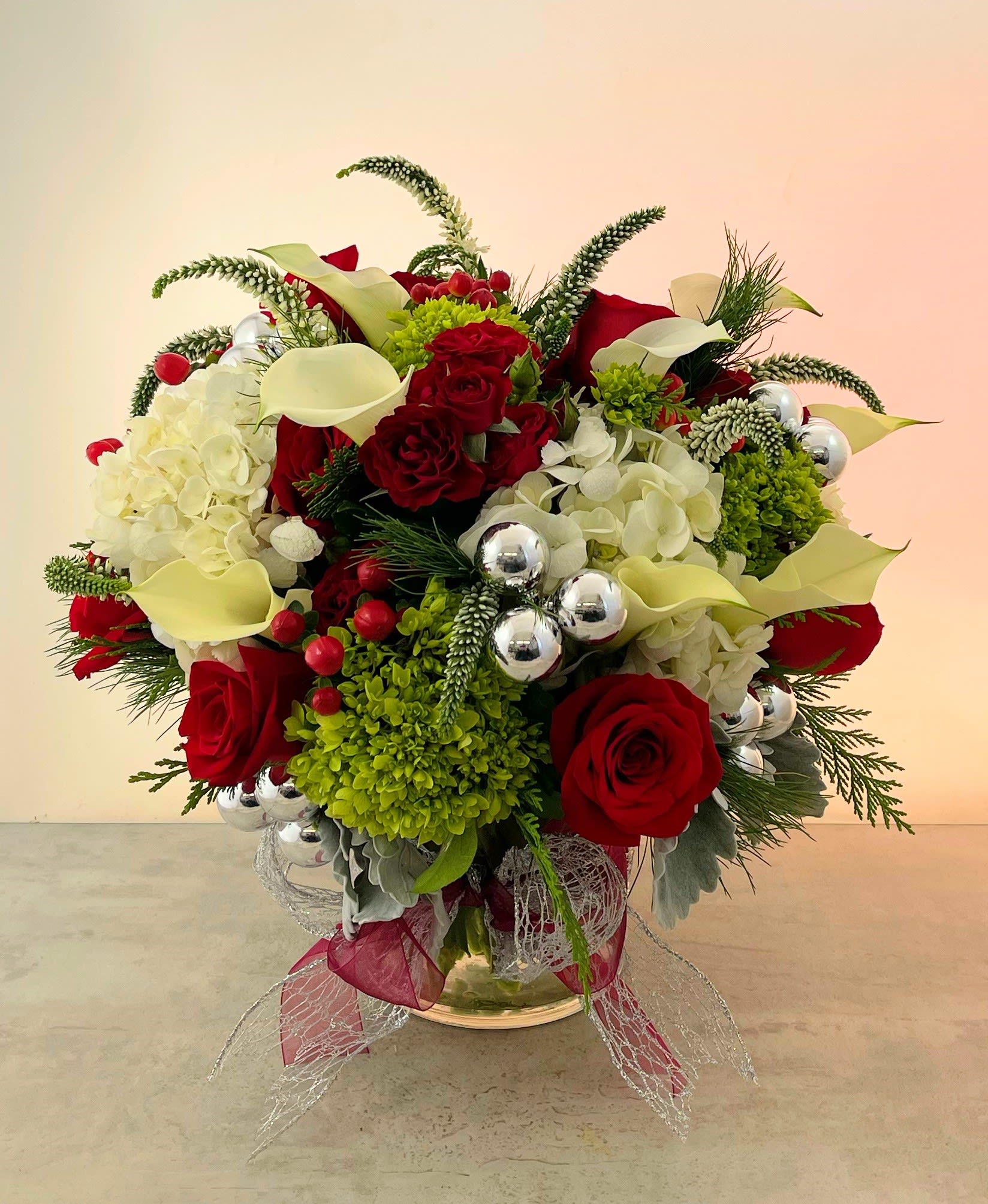 Christmas Elegance - The Christmas Elegance Bouquet will let your friends and loved ones just how special they are to you this holiday season.  Featuring only the most premium flowers such as crystal blush calla lilies, green hydrangea, red roes and red hypericum berries accented with fine cedar and silver Christmas balls all in a rhinestone encrusted vase. Truly an elegant gift!