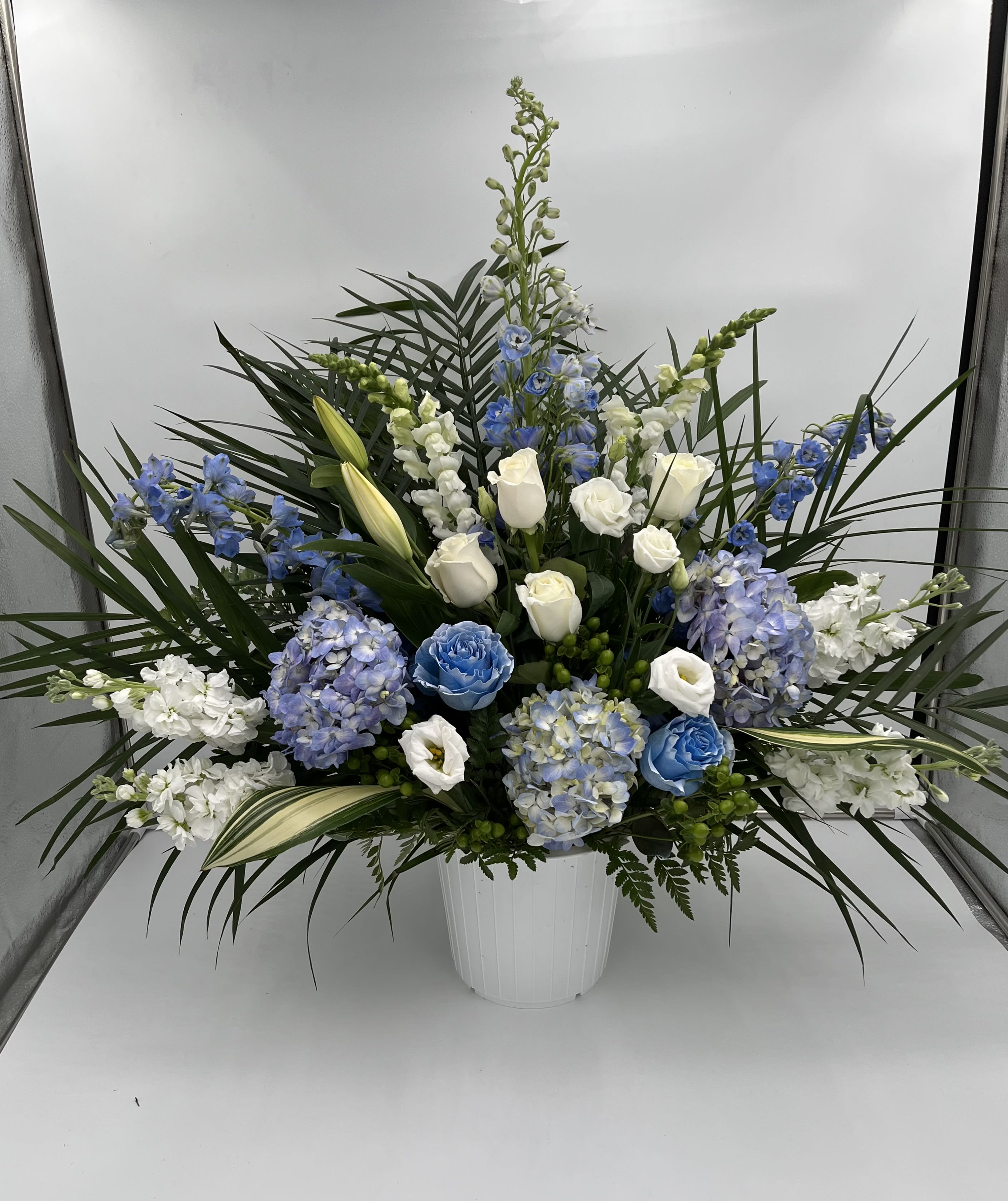 Towards Blue Skies - Traditional floor sympathy basket including hydrangea, roses, snapdragon, delphinium, stock and lizianthus.