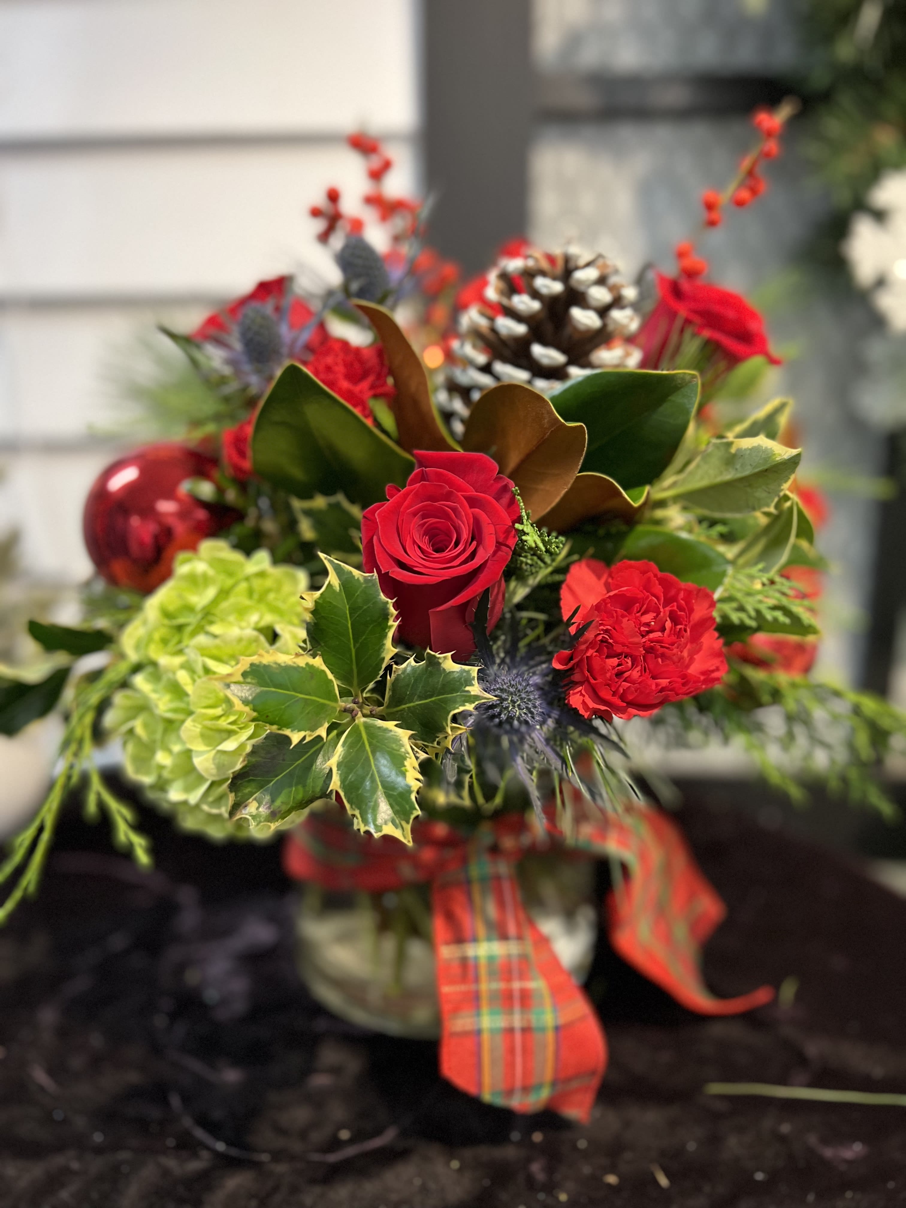Christmas Cheer Arrangement - Cheerful holiday arrangement that includes, a nice mix of winter greenery, roses, carnations, hydrangea, pine cones, millimeter balls, berries and pine cones. Flowers &amp; colors may vary! LOCAL DELIVERY ONLY PLEASE!
