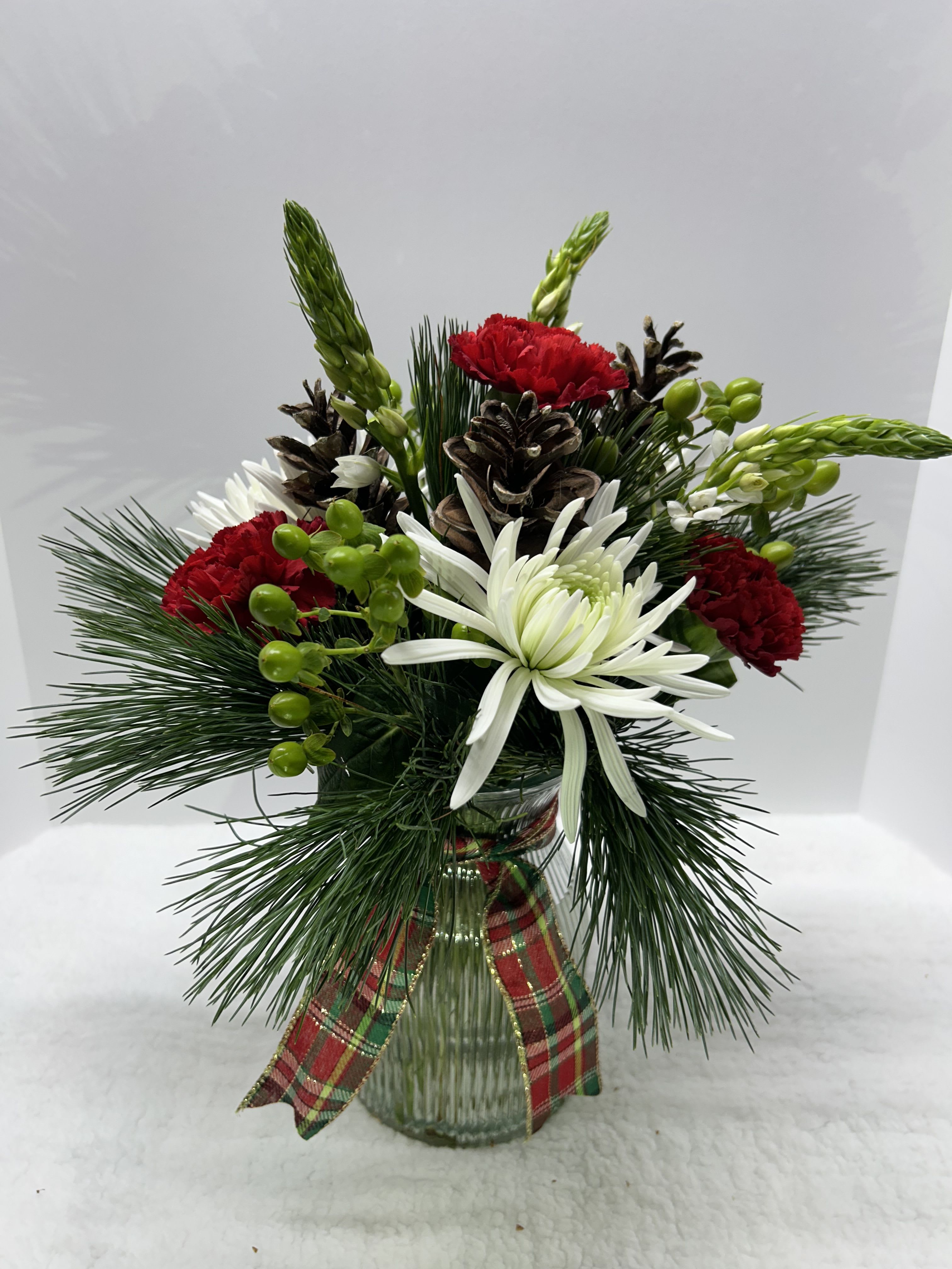 Glad Tidings - Clear vase with mixed greens, fresh flowers &amp; plaid box.