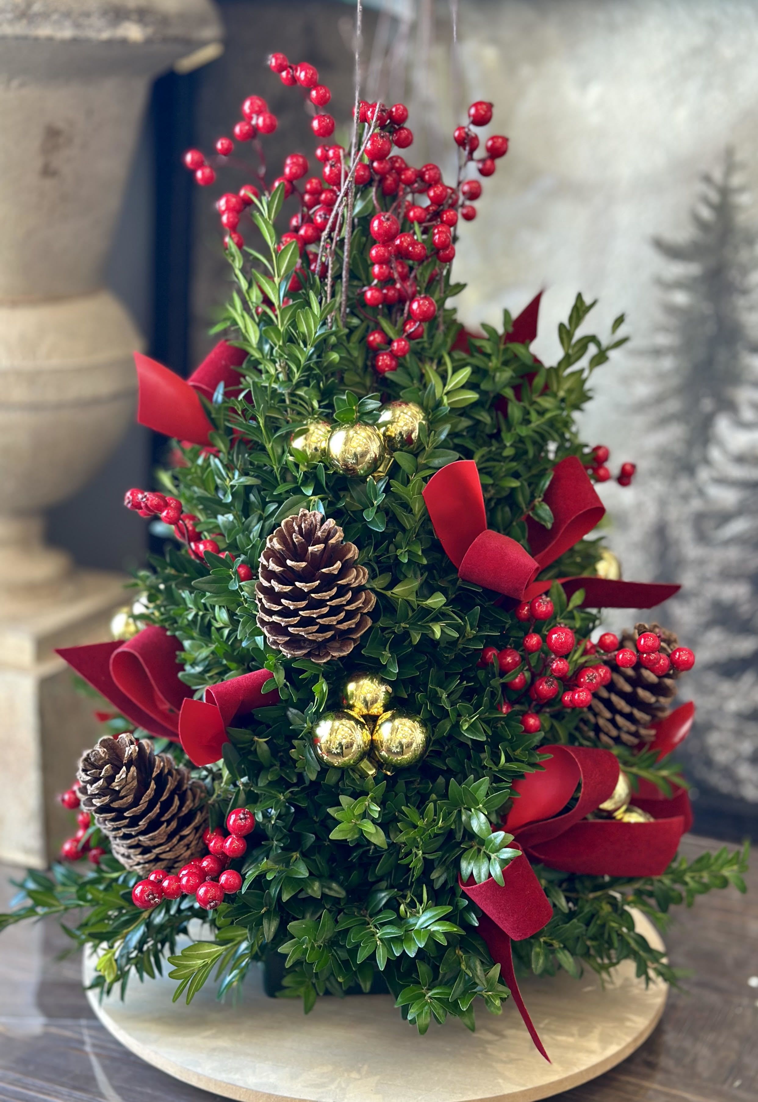 Festive Boxwood Tree - Fresh boxwood tree decorated with the New England natural touch of berries, pine cones &amp; bows. (Can customize your own boxwood tree with different color selections, please specify in the &quot;Special Instructions&quot; section) Colors may vary! Local delivery ONLY please! This is a table centerpiece, not a live tree.