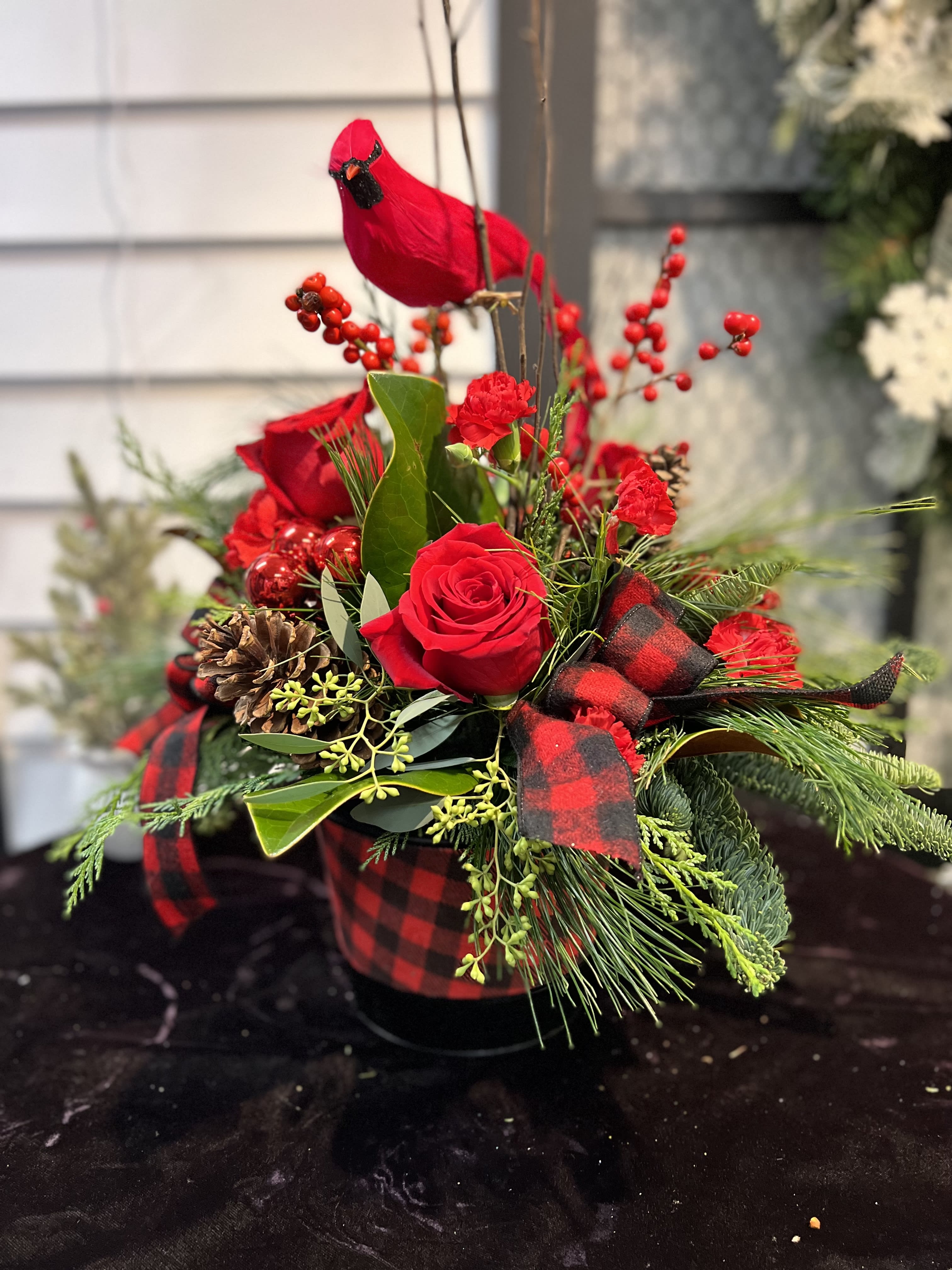 Joyous Wishes - Fresh holiday arrangement that includes; roses, carnations, mini carnations, millimeter balls, pine cones, berries, mixed winter greenery and a faux cardinal. Designed in a keepsake container. Flowers &amp; colors may vary! LOCAL DELIVERY ONLY PLEASE!