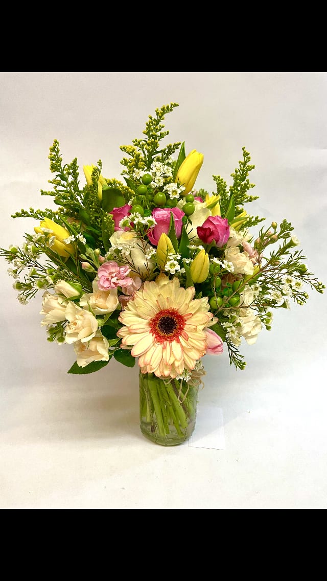 Soft and Bright Garden Jar. - This bright arrangement features variety of roses, solidago, tulips, stock, wax flower, spray roses, hypericum, gerbera daisies and variety of greenery. (Some flowers may be subject to change depending on the season. We will contact you with available flower substitutions; please contact us with specific questions if you are concerned with flower availability, thanks!) FEATURED ARRANGEMENT: $88.75 (REGULAR PRICE)