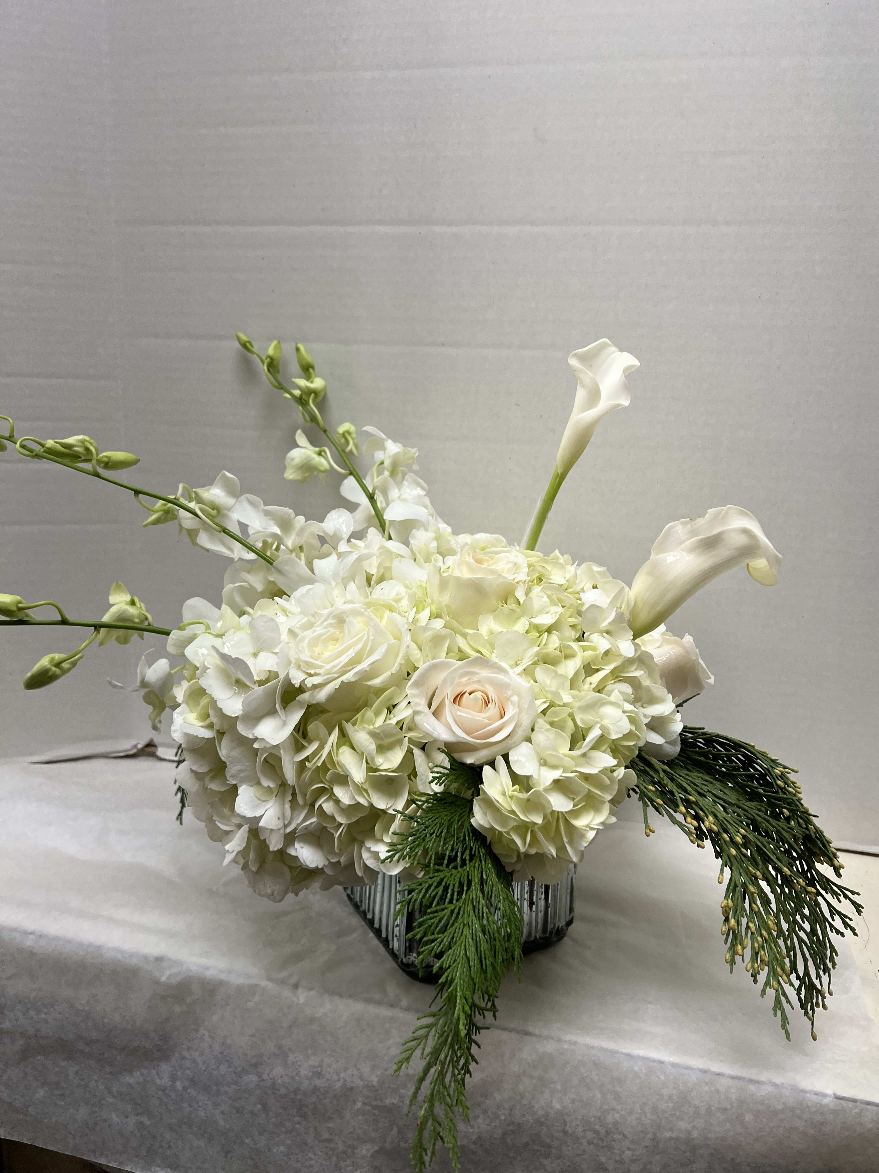 Snowflakes Bouquet  - Elegant all white arrangement in a silver cube of white hydrangea, white mini callas, white orchids and white roses with holiday greenery 