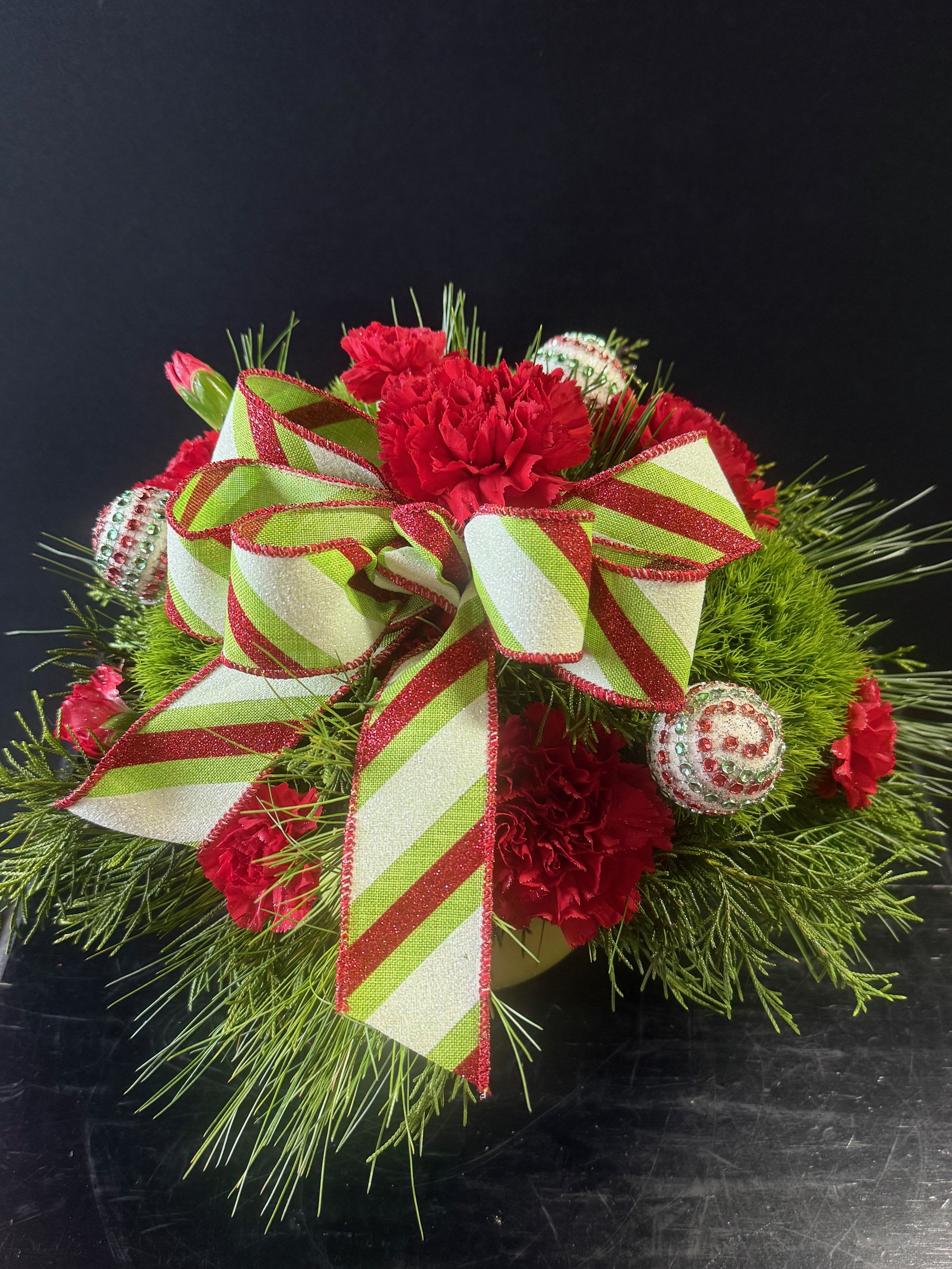 Glitter Grinch - Round green ceramic bowl with wintergreens, carnations, mini carnations, trick and little ornaments 