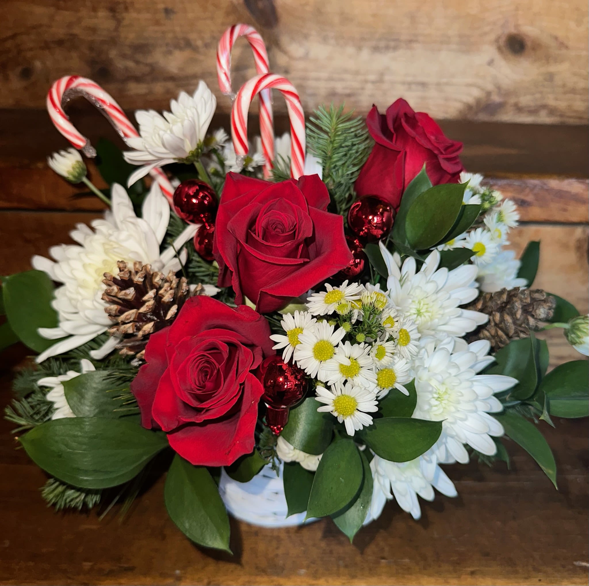 Christmas Candy Land Basket - Red roses, white chrysanthemums, balsam and white with candy canes, pinecones, ornaments, in a white basket