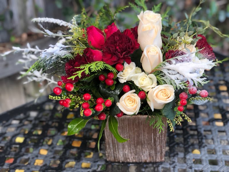 Holiday Magic - Spread the holiday joy with this lovely design. Joyful pops of red accents including red roses, red berries, a splash of pink and evergreen accents covered in light artificial snow. 
