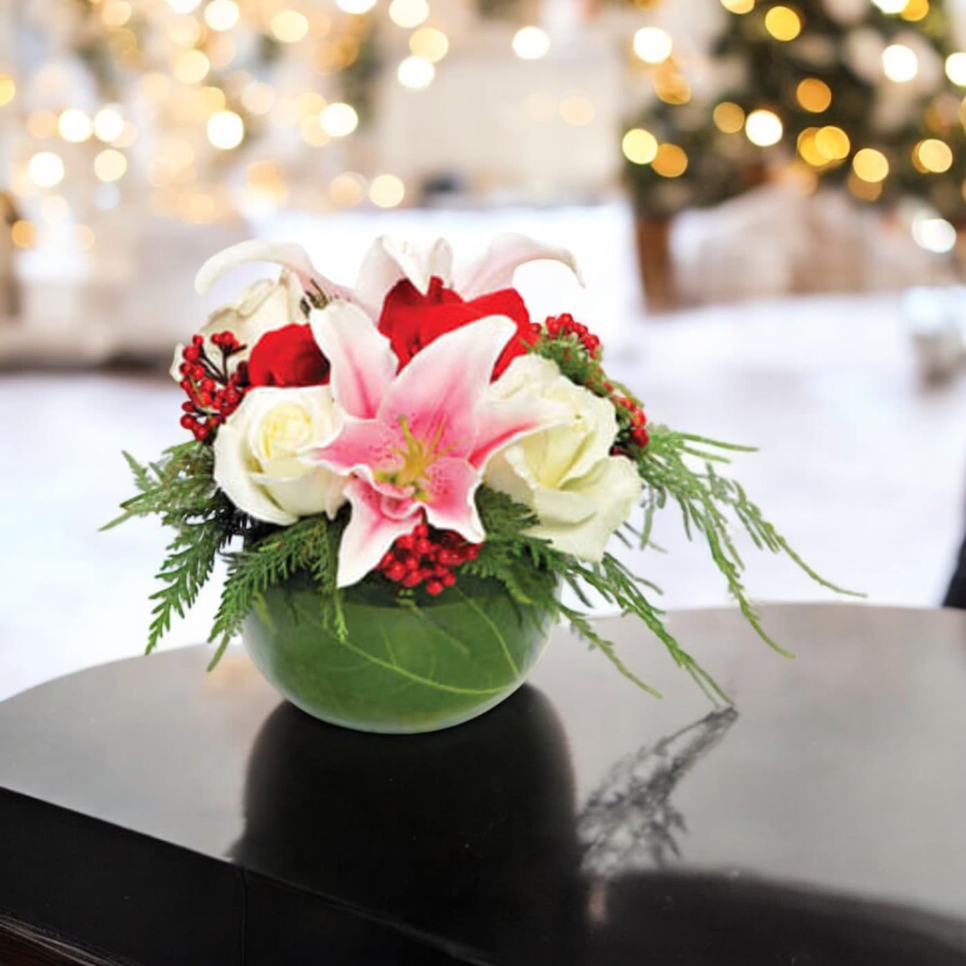 Holiday Bubble Bowl Centerpiece - Red and White Roses and lilies Accented with Red Berries with Leaf Lined Bubble Bowl.