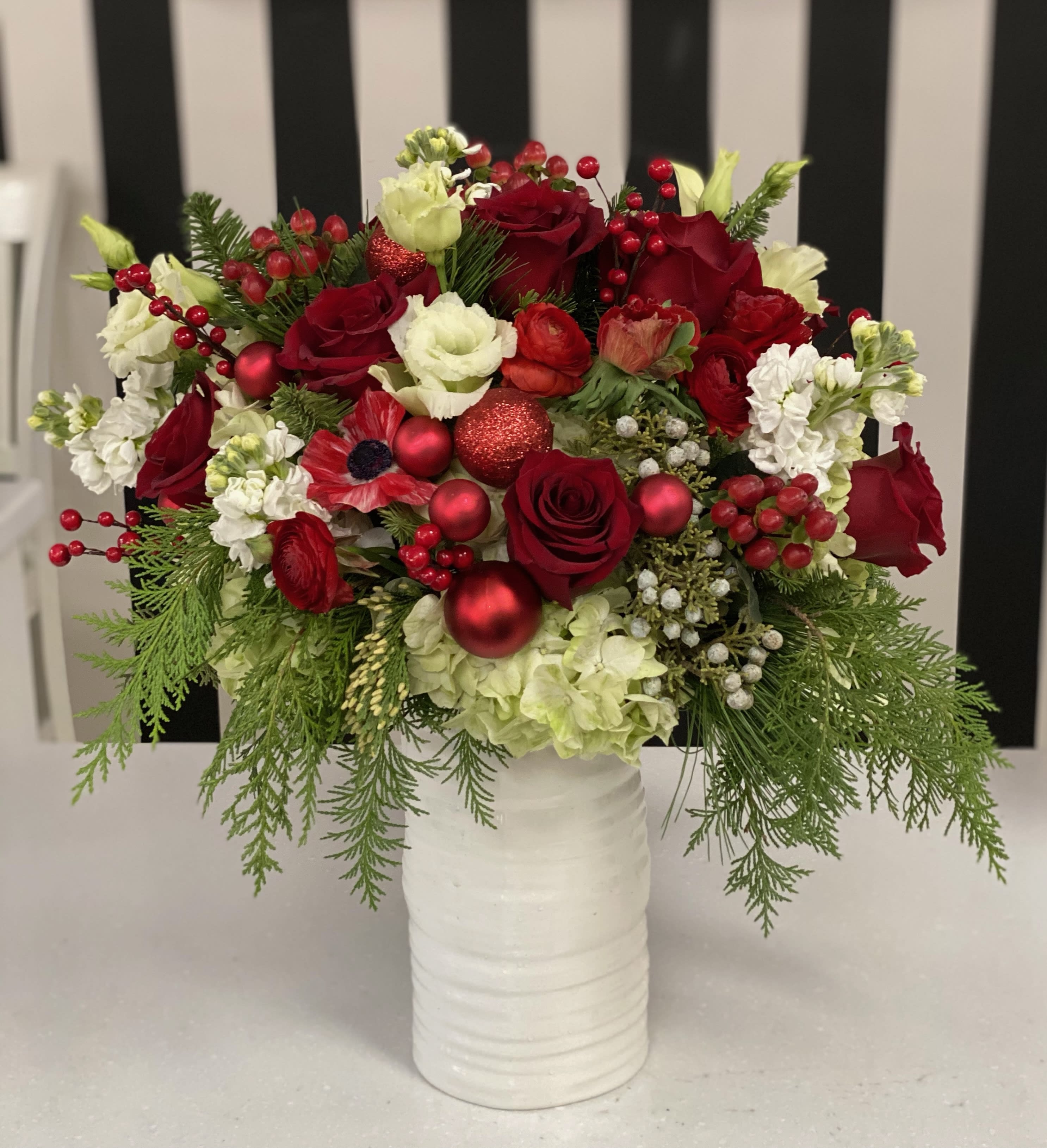 Jolly Christmas - White tall vase filled with Christmas Greens, Red and White flowers, Ornaments and pinecones