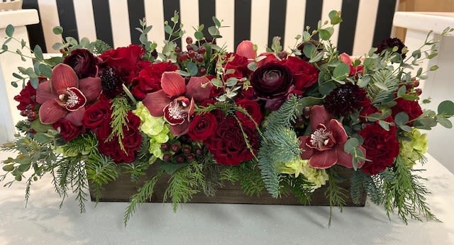 Crimson Christmas - A wood box filled with deep, rich  red tones including roses, spray roses, ranunculus, orchid, hydrangeas, Christmas greens and more. 