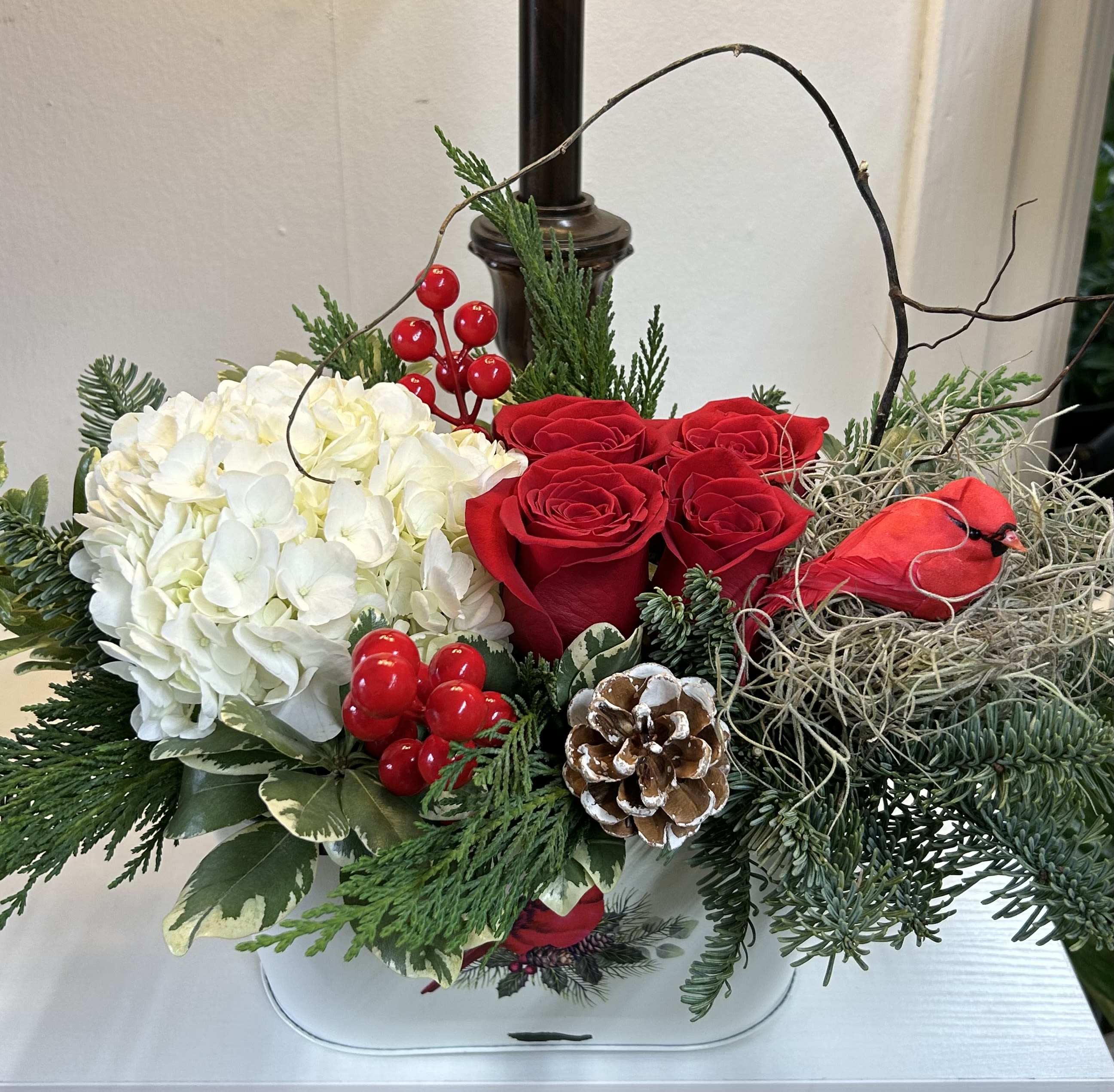 Christmas cardinal arrangement - White hydrangeas, red roses with Christmas green, arranged in a cardinal planter