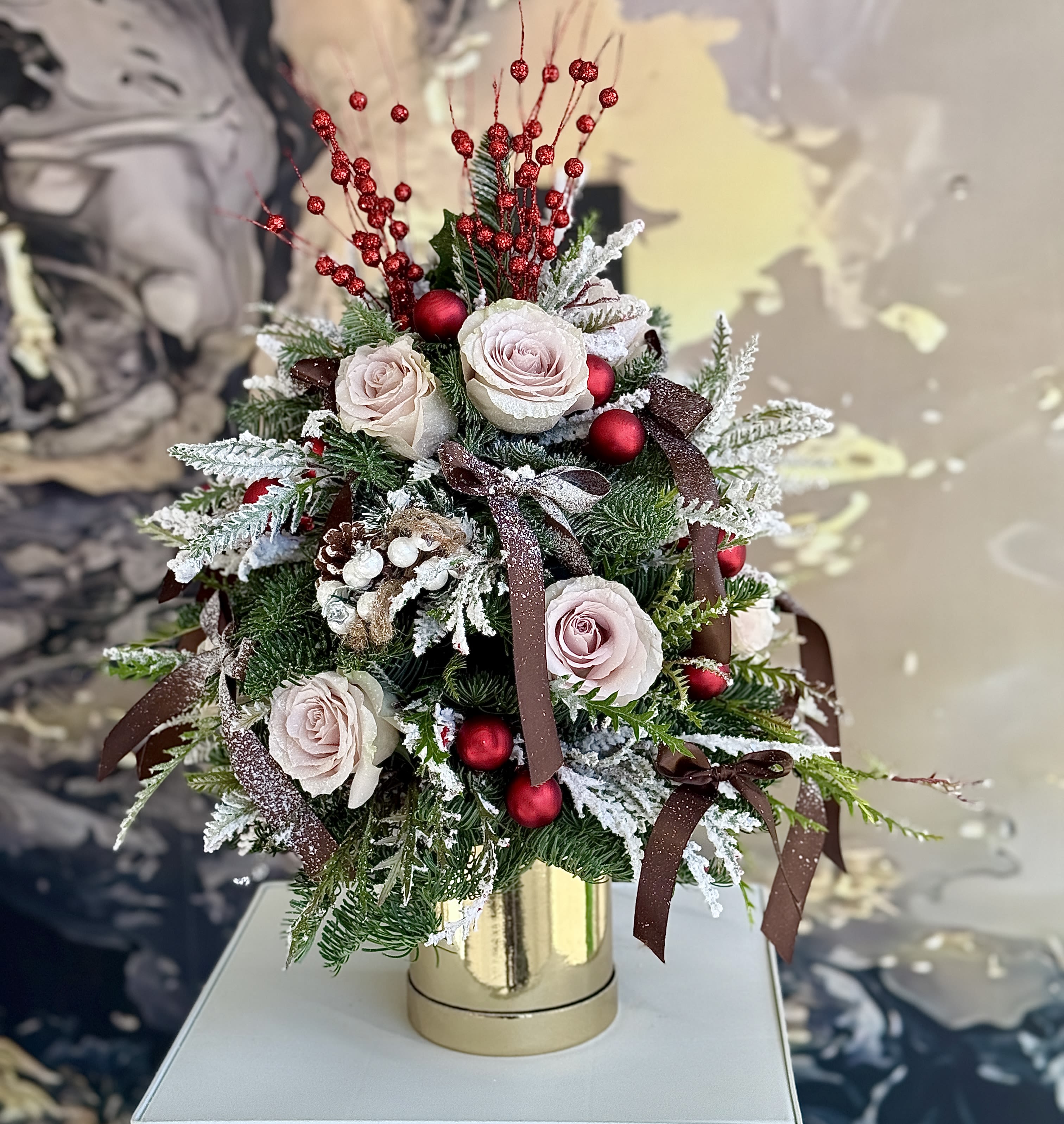 Holiday bloom - Brighten any space with our Elegant Holiday Flower Arrangement! Bursting with vibrant blooms, this stunning display combines seasonal favorites with lush fillers.  Housed in a chic, reusable container, it makes a perfect centerpiece for any occasion be it a gift or a treat for yourself. Elevate your decor with this captivating arrangement that brings joy and sophistication to your home or office. Order yours today and let the beauty of flowers inspire you!