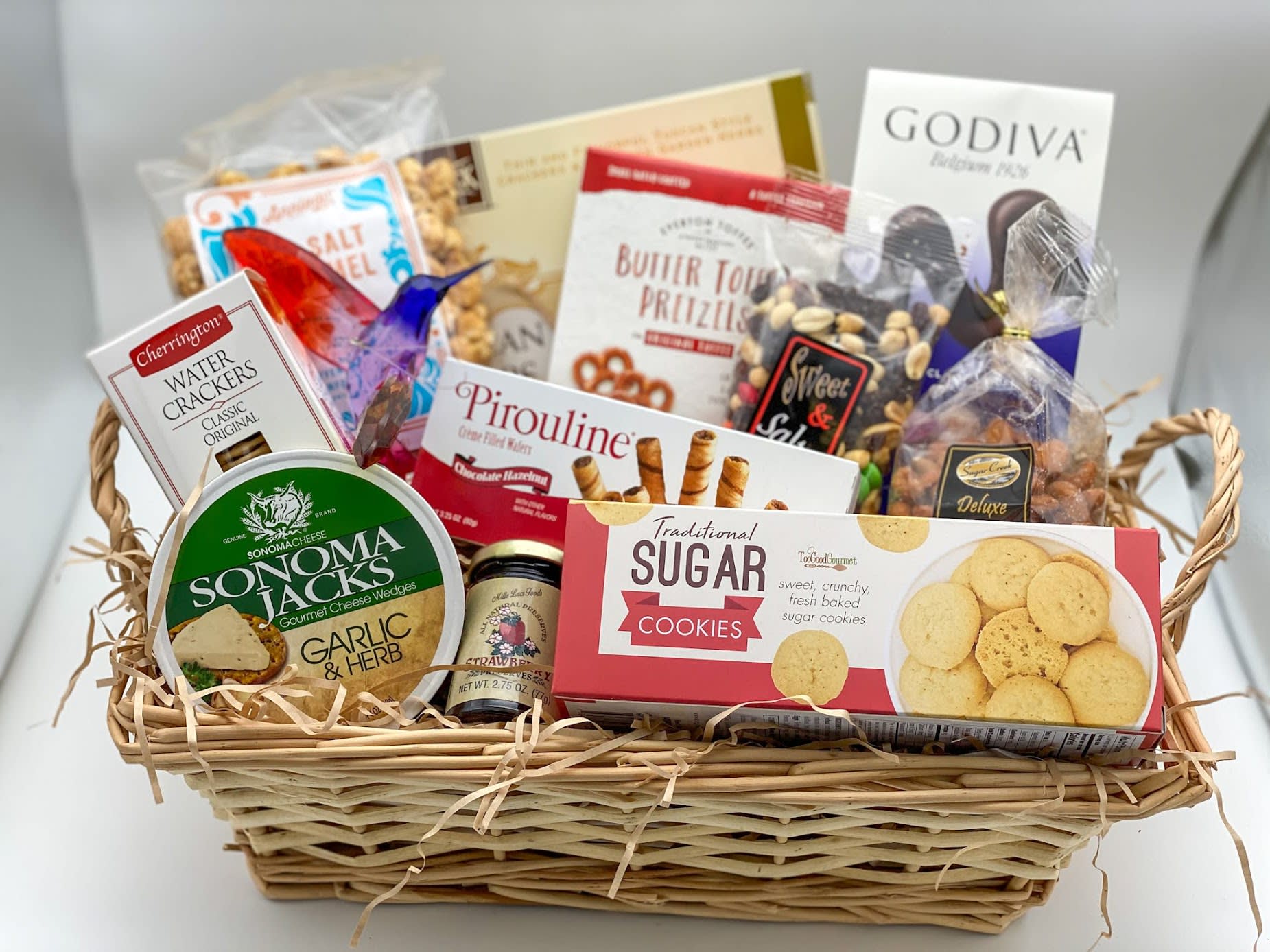 Gourmet Gift Basket - An assortment of gourmet goodies including cookies, crackers, chocolates, pretzels, nuts and more. All arrangement in a wicker basket and wrapped up with cellophane and a ribbon appropriate for the occasion. Gift items appropriate for the occasion can be added - call for more options! 
