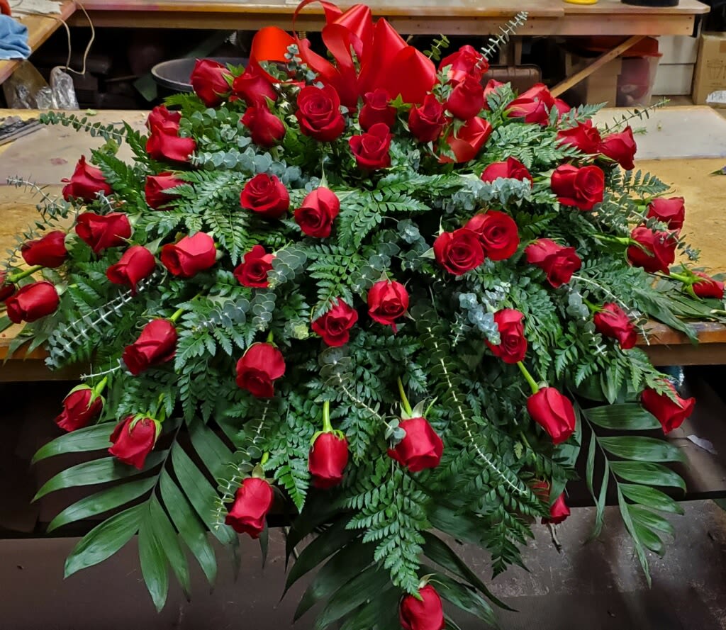 Red Rose Casket Spray - An abundance of beautiful red roses and greens and bow.  Banners additional