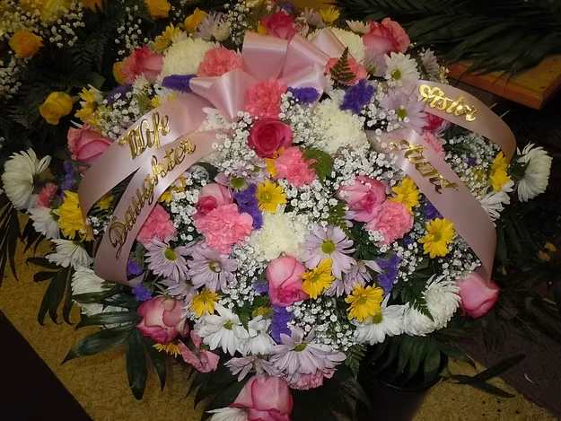 C1 Casket Spray - Casket spray with a mix of white fuji mums, lavender, white and yellow daisies, pink carnations, purple statice, medium pink roses, baby's breath, and greens.   Banners - $15.00 + extra  Substitutions may apply, pending flower availability.