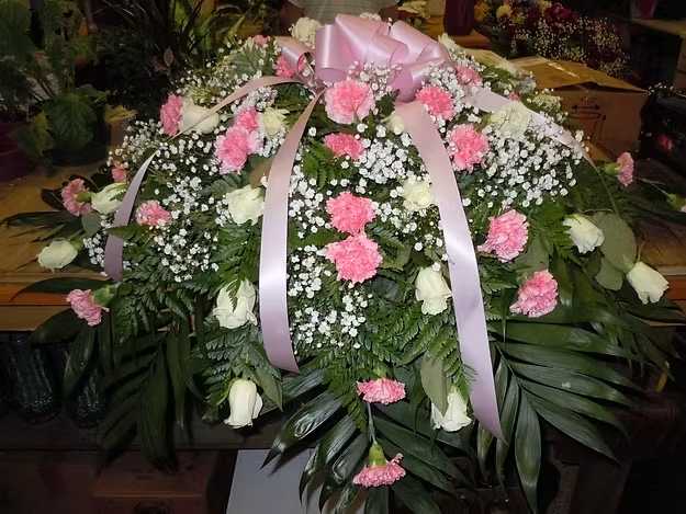 C4 Casket Spray - Casket spray - a mix of white roses and pink carnations, baby's breath and greens.  Banner - $15.00 + extra  Substitutions may apply, pending flower availability.