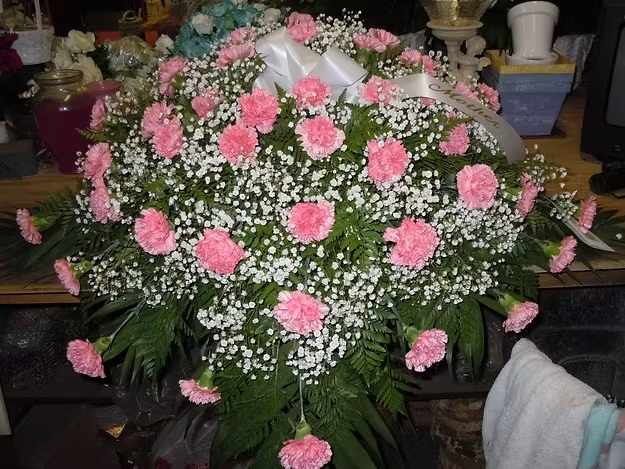 C5 Casket Spray - Casket spray - all carnations, baby's breath and greens.  As shown all pink.  Can sub with different color carnations - ie: all red etc...  Banner - $15.00 + extra  Substitutions may apply, pending flower availability.