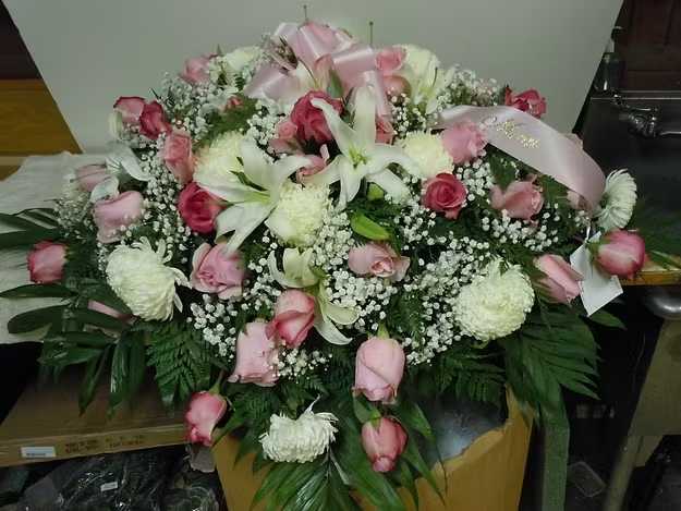 C6 Casket Spray - A mixture of white fuji mums, sweet unique roses, white lilies, greens, and baby's breath.   Banner - $15.00 + extra  Substitutions may apply, pending flower availability.