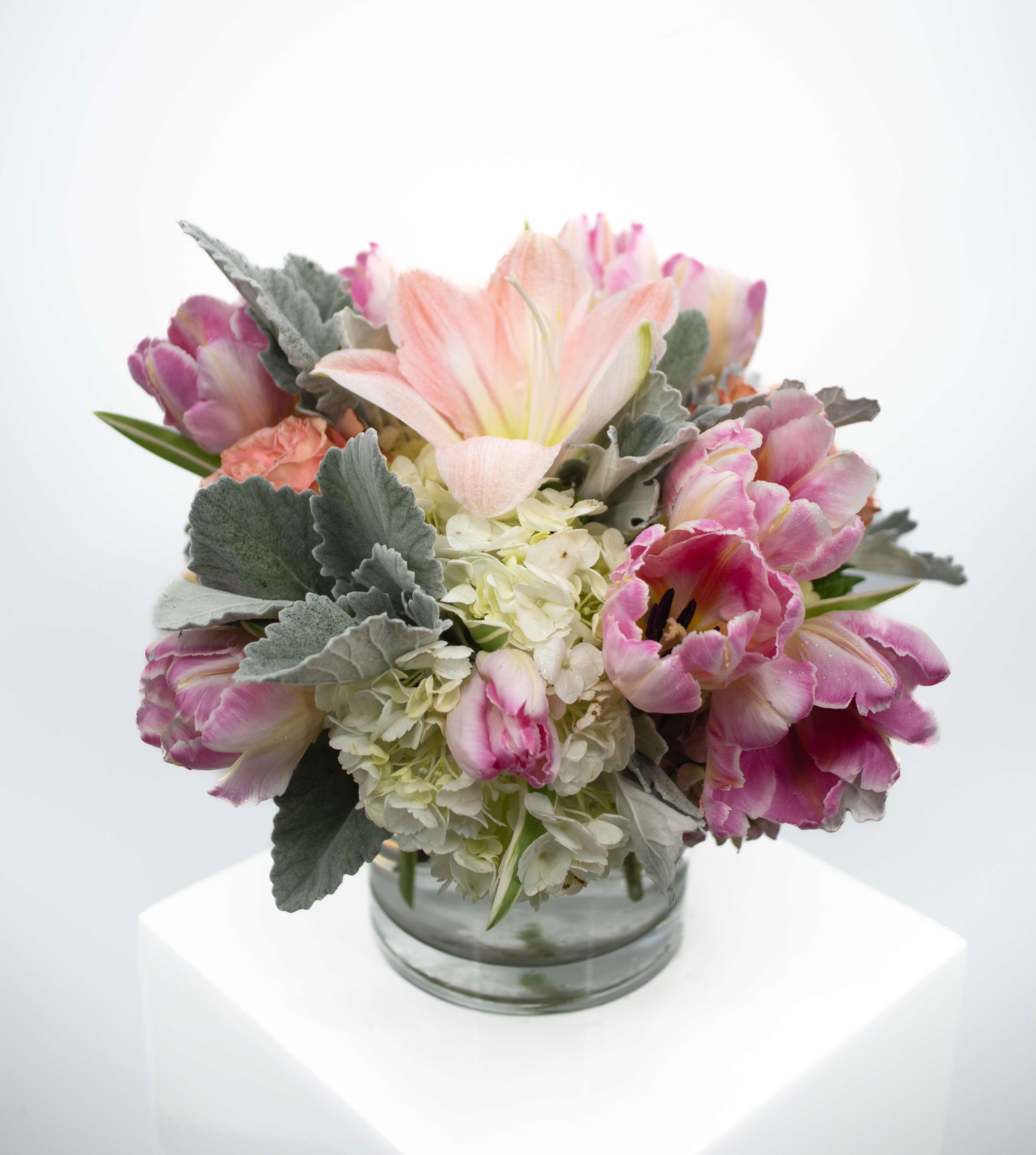 Tallula  - Introducing Tallula, a harmonious blend of nature's finest – tulips, hydrangea, lilies, &amp; Earth Tone greenery gracefully arranged in a timeless classic vase. Elevate any space with the vibrant colors and delicate fragrances of these premium blooms. Perfect for special occasions or to simply bring the beauty of the outdoors indoors. Make a statement with (Tallula) – where sophistication meets nature's artistry