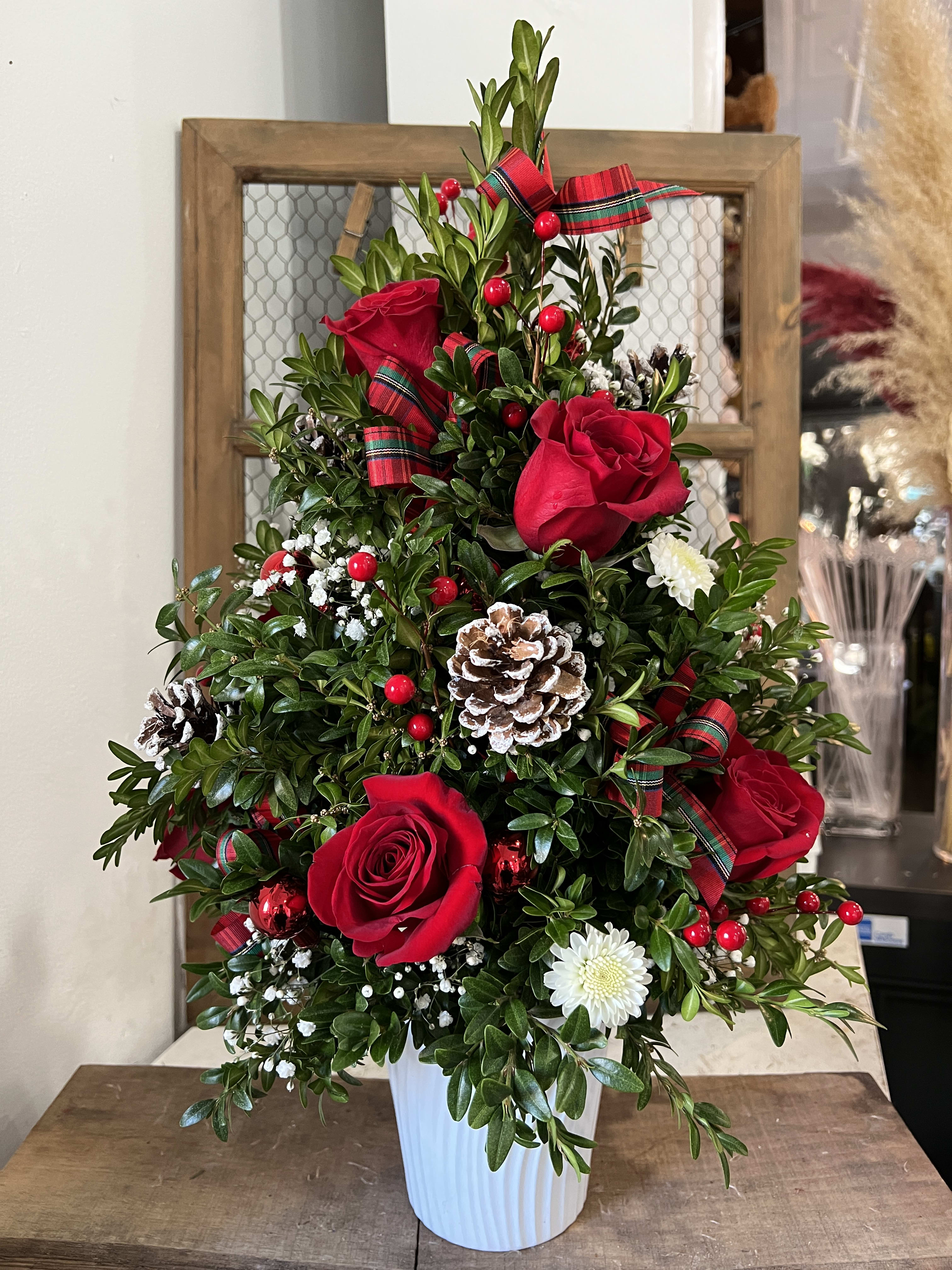 Boxwood Christmas Tree - Our Christmas Boxwood Tree is a beautiful miniature Christmas tree complete with the traditional holiday décor and some added fresh beauty- red and white blooms! Topped with a red bow, this adorable tree brings fun, life, and holiday spirit from just one glimpse. Size: 17&quot; tall  Delivery minimum is $50.00 Our DELIVERY SERVICE IS TILL 3 PM We cannot guarantee requests for a specific time of delivery. There might be flower substitutions, due to low supply of certain flowers. However, we do our best to provide you with the same look and feel of the arrangement. Our main goal is to always give our customers quality flowers and service. To make sure that you get the exact same flowers, ordering a few days ahead of desired delivery date is key.