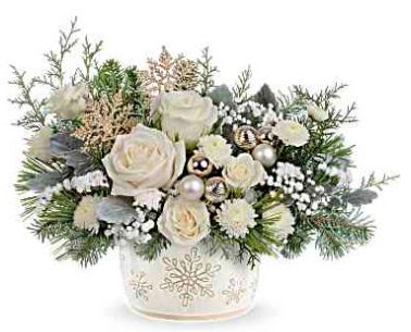 Starry Snowflakes - Create unforgettable holiday memories with this special delivery of classic Christmas roses, elegantly presented in a hand-painted, distressed serving dish centerpiece adorned with a charming snowflake design. Perfectly food-safe, it adds a festive touch to your seasonal celebrations. Teleflora's Starry Snowflake Centerpiece showcases white roses, spray roses, and button spray chrysanthemums, accented with sinuata statice and gypsophila. Designed with dusty miller, noble fir, white pine, and cedar, presented in Teleflora's Snowflake Symphony Dish, it creates a timeless holiday centerpiece.