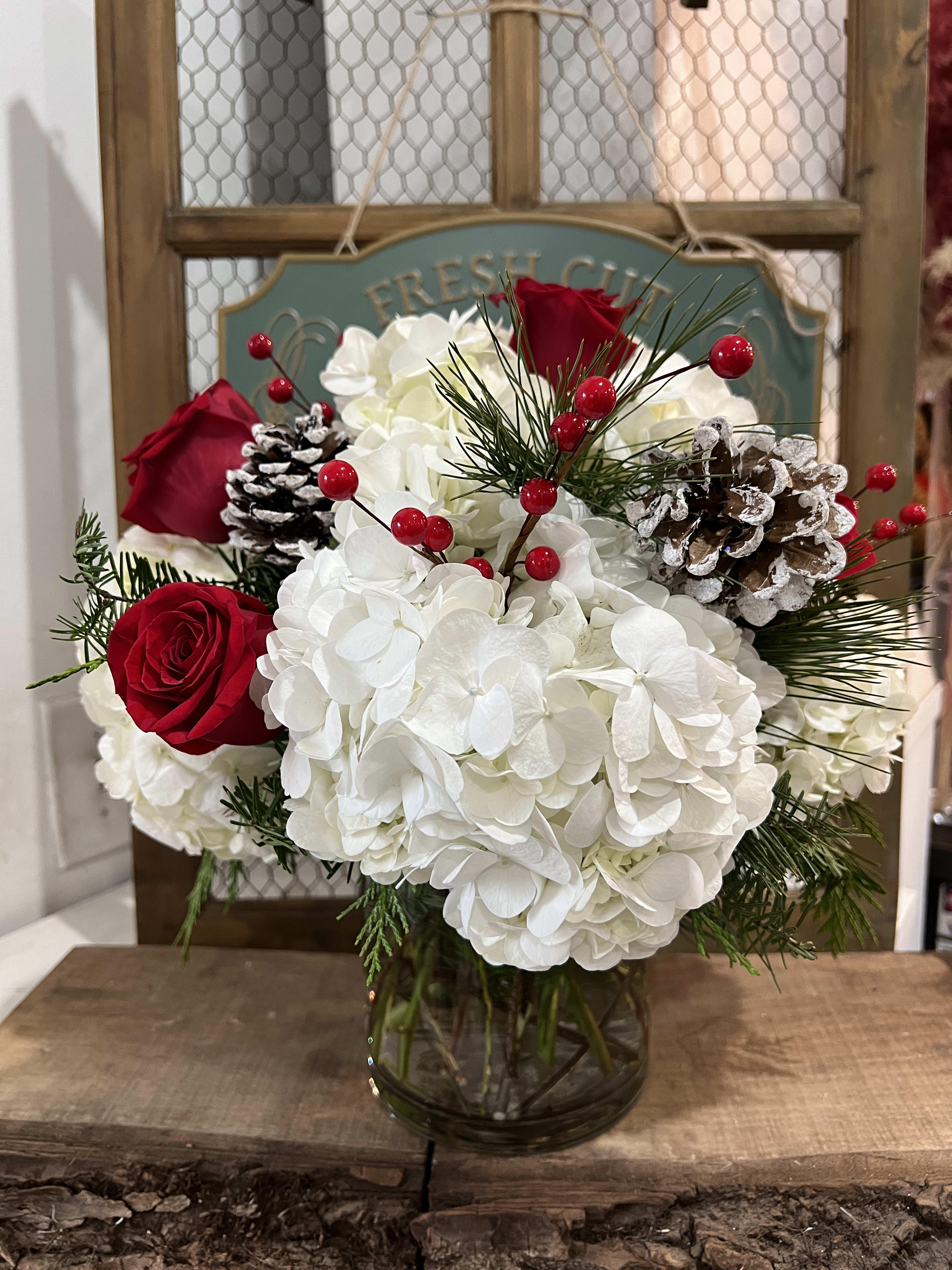 Christmas Miracle  - A magical combination of hydrangeas, roses, berries and pine cones.  Delivery minimum is $50.00 Our DELIVERY SERVICE IS TILL 3 PM We cannot guarantee requests for a specific time of delivery. There might be flower substitutions, due to low supply of certain flowers. However, we do our best to provide you with the same look and feel of the arrangement. Our main goal is to always give our customers quality flowers and service. To make sure that you get the exact same flowers, ordering a few days ahead of desired delivery date is key.