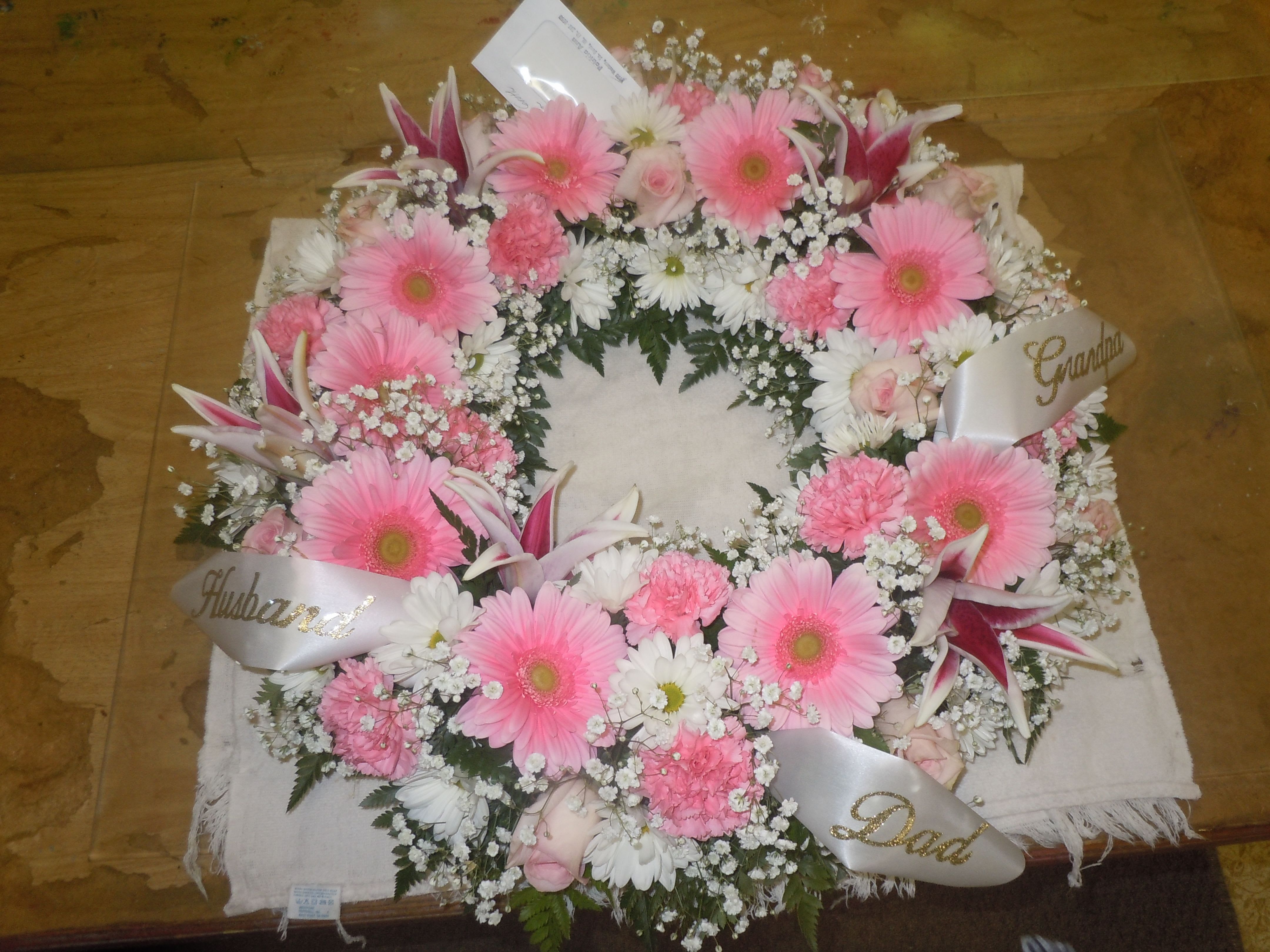 UR1 Urn Wreath -  URN WREATH - UR1 PrevNext  A mixture of gerbera daisies, roses, carnations, daisies, and greens.  (this can be made in any choice colors)  Banner - $15.00 + extra  Substitutions may apply due to flower availability