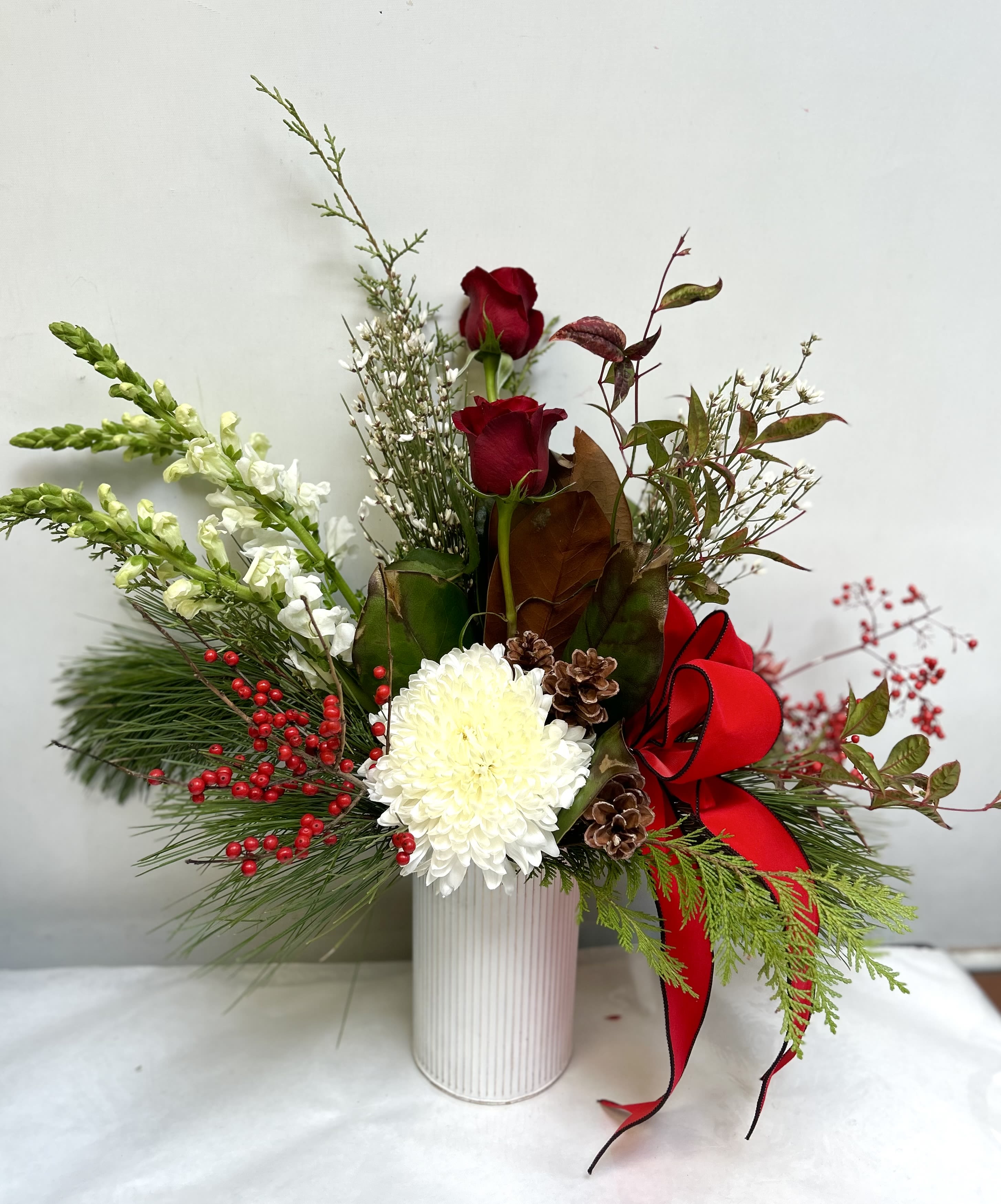 Sylvia's Winter Garden - Metal can filled with seasonal favorites. Includes red roses, cinnamon sticks, genistra, standard chrysanthemum, stock, sparkle branch, thistle, pine and a bow in a trendy corrugated metal can.  HFS 201612-12