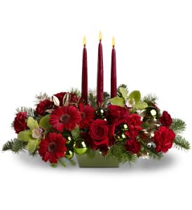 Dreaming of Christmas - Are you dreaming of a bright Christmas? Then make this stylish centerpiece the center of your holiday festivities. A medley of red and green blooms - including roses and orchids - is arranged with ornaments and evergreens around three tall taper candles. Truly sensational!  A mix of red and green flowers such as roses, Cymbidium orchids, carnations and miniature gerberas – accented with ornament balls and evergreens - are arranged in a dish around three 12” tapers.  Approximately 20" (W) x 16" (H)  Orientation: All-Around  As Shown : TFWEB483