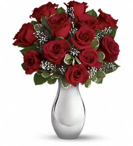 Teleflora's Winter Grace Bouquet - One dozen ravishingly red roses showcased in a stunning silver reflections vase - what a glorious Christmas bouquet. Classic and contemporary at the same time, it is a gift they'll love - with a dazzling keepsake vase they'll treasure.  The spectacular holiday bouquet features 12 red roses accented with assorted greenery.  Approximately 12 1/2" W x 16" H  Orientation: All-Around  As Shown : T408-1A Deluxe : T408-1B Premium : T408-1C