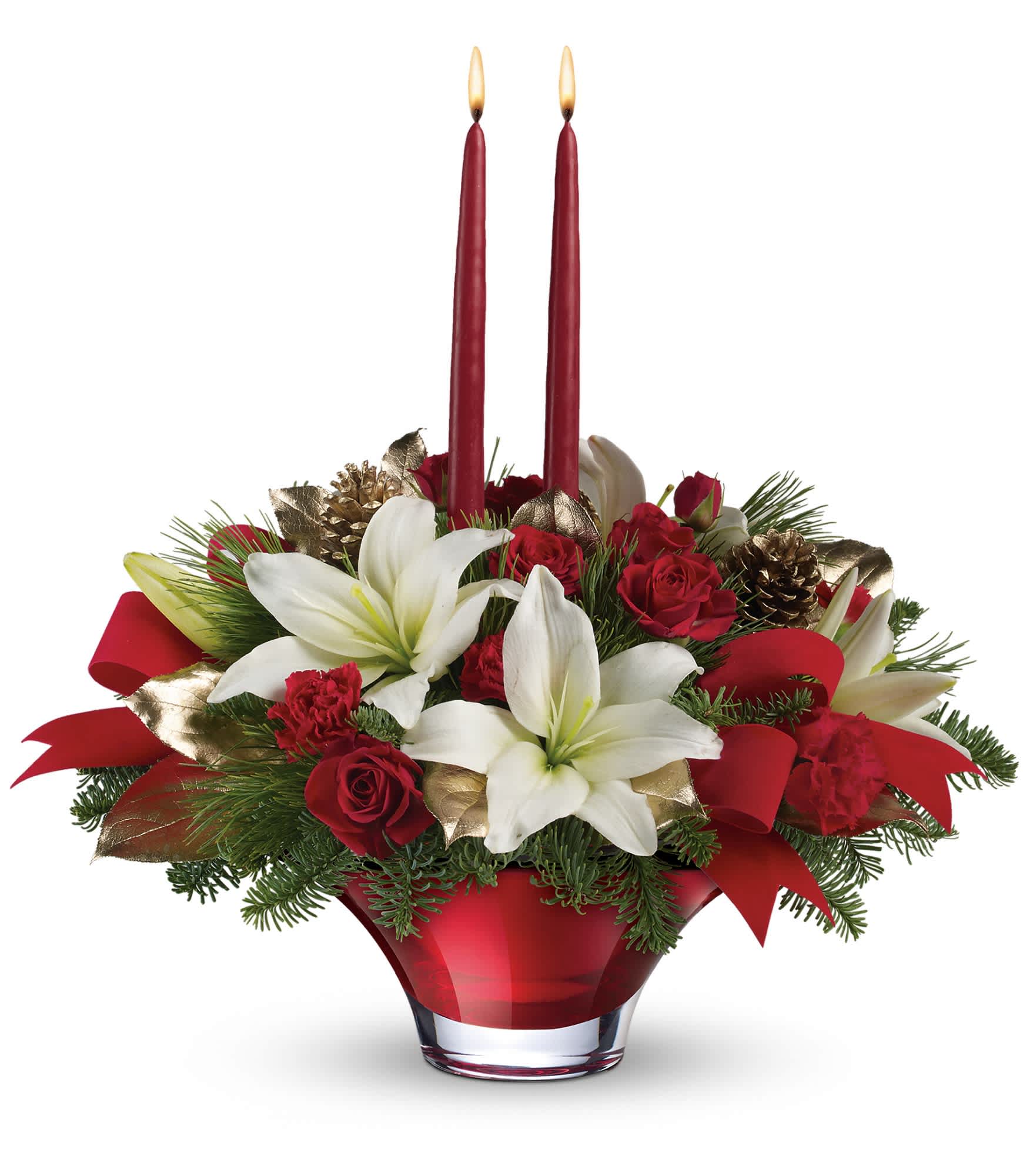 Teleflora's Crimson Glow Centerpiece - Red spray roses, white lilies and miniature red carnations are accented with noble fir, white pine, lemon leaf, golden pinecones, red velveteen ribbon and red taper candles. Delivered in an exclusive Holiday Flair bowl. Approximately 16" W x 15 1/2" H.  T13X210A