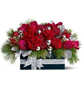Gift of Roses - Does someone deserve a gift of roses this Christmas? This gorgeous blend of rosy blooms and frilly evergreens, accented with shiny silver ornaments and silver-sprayed leaves, is delivered in a wooden box adorned with a fancy silver ribbon.  A mix of fresh flowers such as red roses, gladiolus and carnations is accented with evergreens, silver-sprayed leaves and silver ornament balls, and arranged in a wooden box decorated with a silver ribbon.  Approximately 20" (W) x 13" (H) Orientation: All-Around  As Shown : TFWEB263