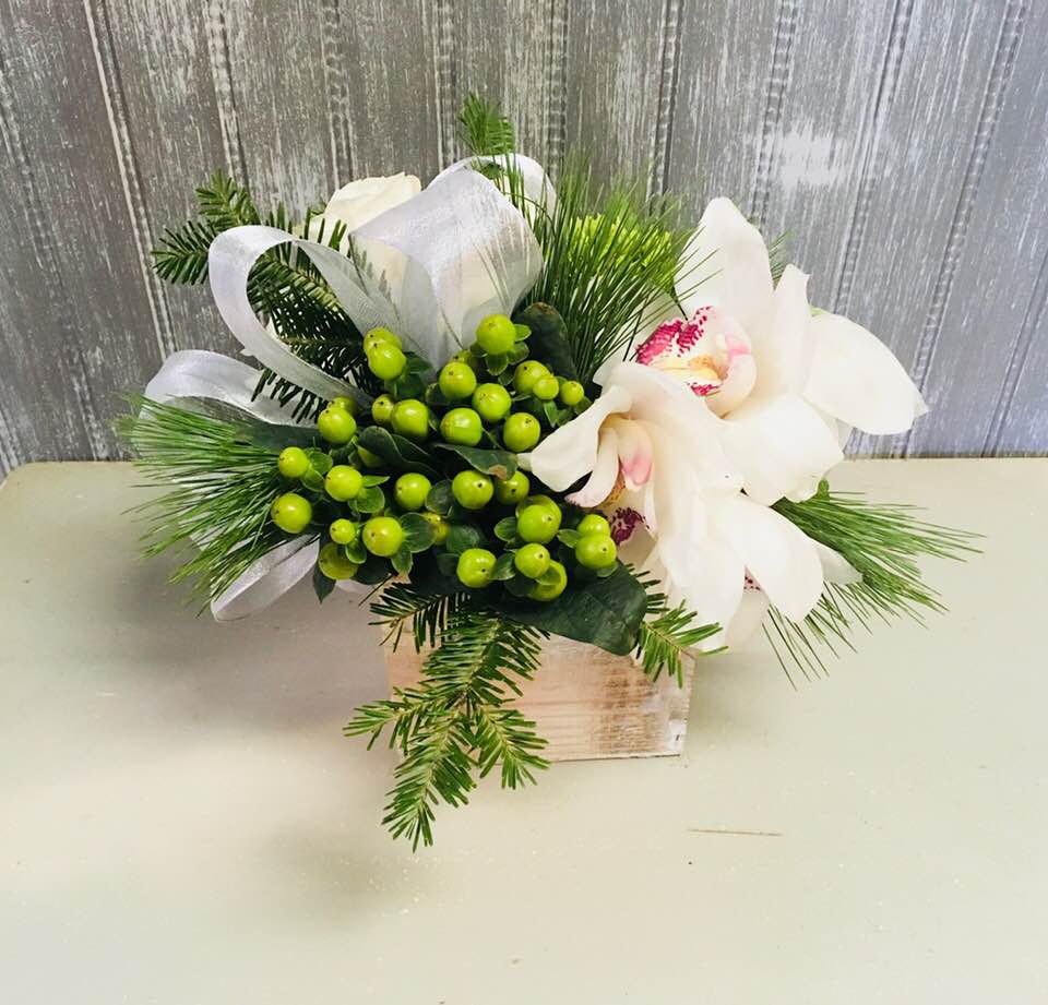 Missy Winter - Simple seasonal cube arrangement in shades of whites and greens, silver ribbon, green berries, white cympidium orchid, roses, pine and mini green hydrangea.  Perfect on it's own as a gift or get a few to go across the holiday table!  Sizing of box is 4",5" and 6".