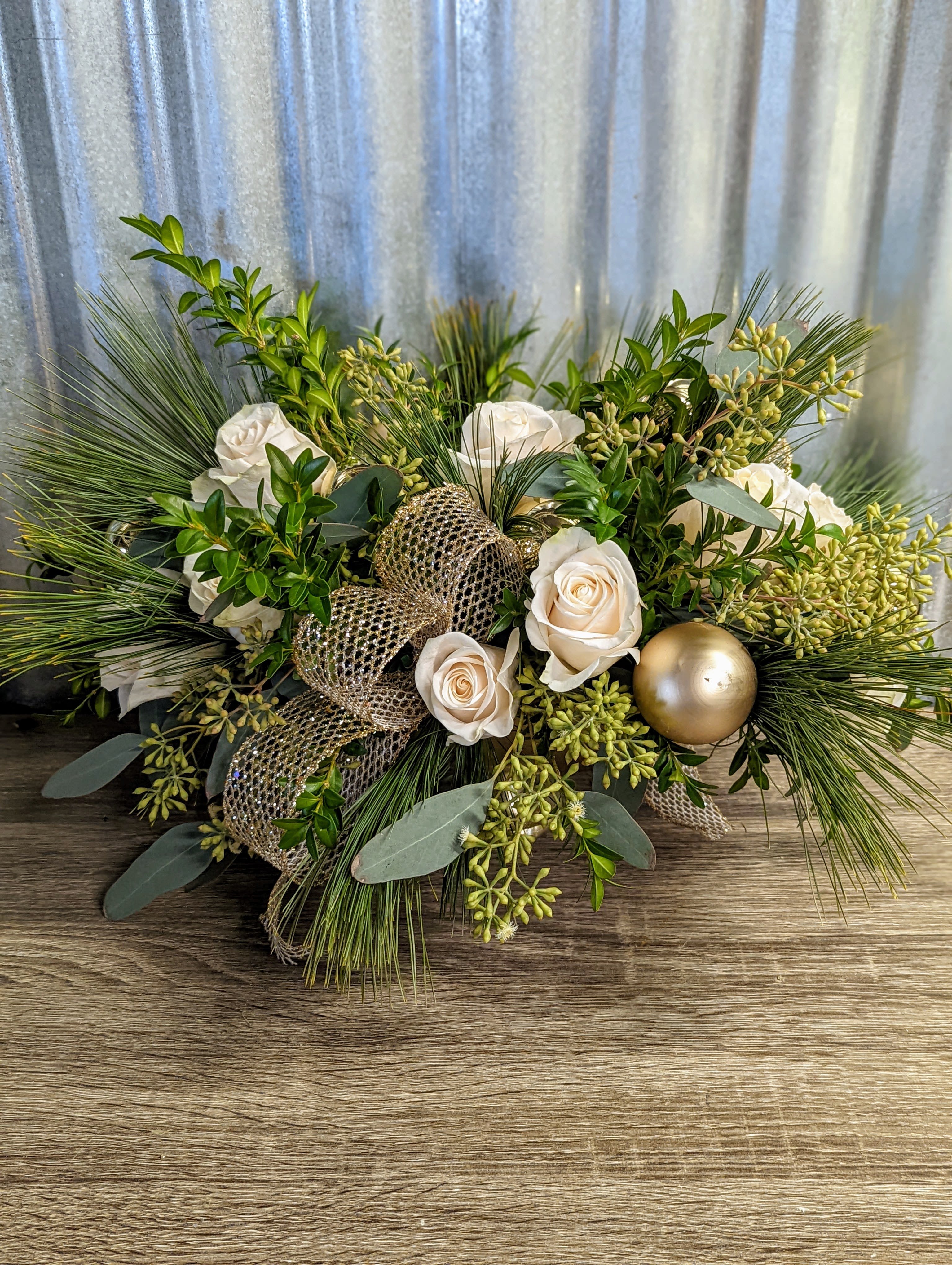 Khione - Simple and elegant green, whites and golds with simple roses and beautiful Christmas accessories, approximate size 12"l x 5"w x 10"h.